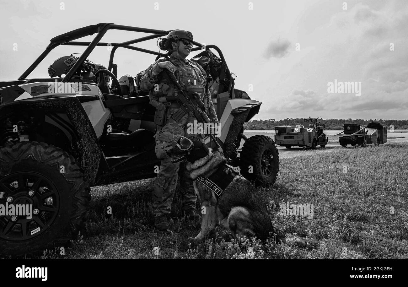 Un chien de travail militaire attaché à la 4e Escadre de chasseurs, la base aérienne Seymour Johnson, attend avec son maître de train lors de l'expérience Agile Flag à Naval Outlating Landing Field Choctaw, Floride, le 3 mai 2021. Le Commandement de combat aérien a développé l'expérience AGILE FLAG 21-2 pour créer une aile de tête, alignant des escadrons de différents endroits sous un seul commandant, améliorant leur état de préparation en tant qu'équipe avant de se déployer dans un environnement contesté. Banque D'Images Un chien de travail militaire attaché à la 4e Escadre de chasseurs, la base aérienne Seymour Johnson, attend avec son maître de train lors de l'expérience Agile Flag à Naval Outlating Landing Field Choctaw, Floride, le 3 mai 2021. Le Commandement de combat aérien a développé l'expérience AGILE FLAG 21-2 pour créer une aile de tête, alignant des escadrons de différents endroits sous un seul commandant, améliorant leur état de préparation en tant qu'équipe avant de se déployer dans un environnement contesté. Banque D'Images