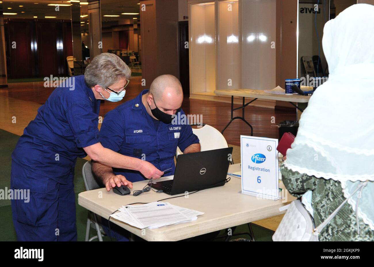 U.S. Coast Guardmen Petty Officer 2e classe William Aycardi, à droite, Et l’officier de première classe Nancy Bartee, de gauche, affecté au secteur de la Virginie, accueille les membres de la communauté alors qu’ils terminent le processus d’inscription au Centre de vaccination communautaire géré par l’État et financé par le gouvernement fédéral de l’ancien Macy’s au Military Circle Mall à Norfolk, en Virginie, le 5 mai 2021. Le Commandement du Nord des États-Unis, par l'intermédiaire de l'Armée du Nord des États-Unis, demeure déterminé à fournir un soutien continu et souple du ministère de la Défense à la FEMA dans le cadre de la réponse pangouvernementale à la COVID 19. Banque D'Images