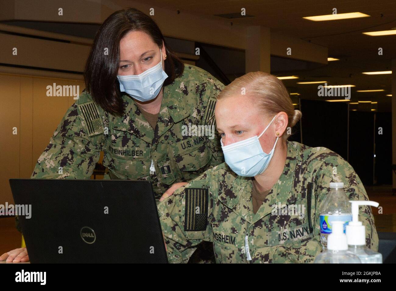 Le lieutenant de la marine américaine Desiree Steinhilber, à gauche, attaché au Naval Medical Center Portsmouth, aide les U.S. Navy Ens. Ann Zingsheim, à droite, avec des tâches administratives au Centre communautaire de vaccination géré par l’État et soutenu par le gouvernement fédéral, dans l’ancien Macy’s du Military Circle Mall à Norfolk, en Virginie, le 6 mai 2021. Le Commandement du Nord des États-Unis, par l'intermédiaire de l'Armée du Nord des États-Unis, demeure déterminé à fournir un soutien continu et souple du ministère de la Défense à l'Agence fédérale de gestion des urgences dans le cadre de la réponse pangouvernementale à la COVID 19. Banque D'Images