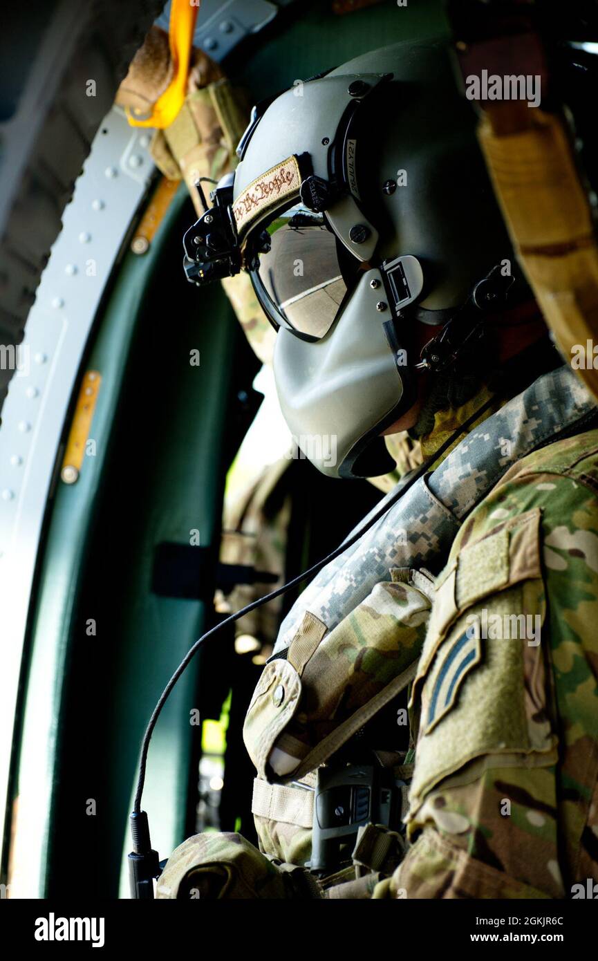Sergent d'état-major de la Garde nationale de l'armée de New York. Jake  Pratt un chef d'équipage UH-60 affecté au 2e Bataillon, 142e Aviation  observe le terrain lors d'un entraînement de lutte contre