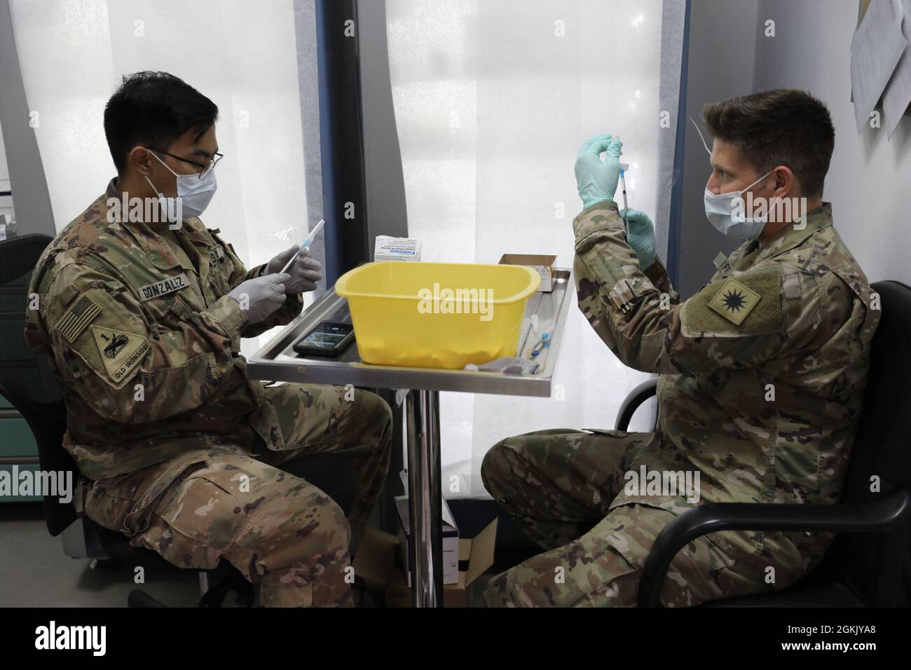 Sgt. Victor Gonzalez (à gauche), Sergent de soins de santé et SPC. Bruce Petty, un spécialiste des soins de santé de la Force opérationnelle Phoenix, Headquarters support Company, 640th Aviation support Battalion, prépare des tirs de vaccins pour distribution à Camp Buehring, au Koweït. Banque D'Images