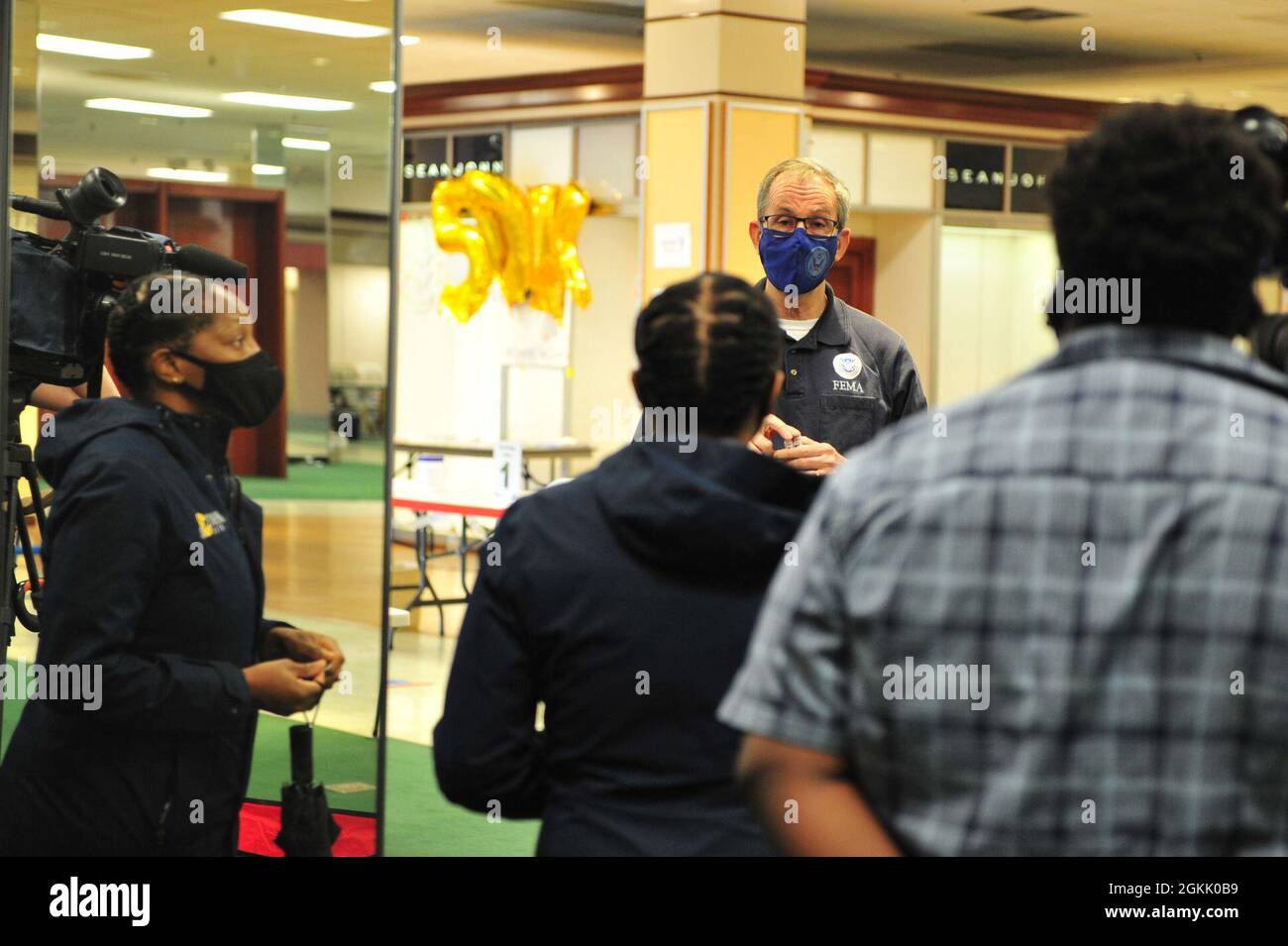 Tim Smith, directeur de site de l’Agence fédérale de gestion des urgences, s’adresse à un journaliste du canal 3 de la WTKR au Centre communautaire de vaccination géré par l’État et financé par le gouvernement fédéral de l’ancien Macy’s, au Military Circle Mall, à Norfolk, en Virginie, le 10 mai 2021. Le Commandement du Nord des États-Unis, par l'intermédiaire de l'Armée du Nord des États-Unis, demeure déterminé à fournir un soutien continu et souple du ministère de la Défense à l'Agence fédérale de gestion des urgences dans le cadre de la réponse pangouvernementale à la COVID 19. Banque D'Images
