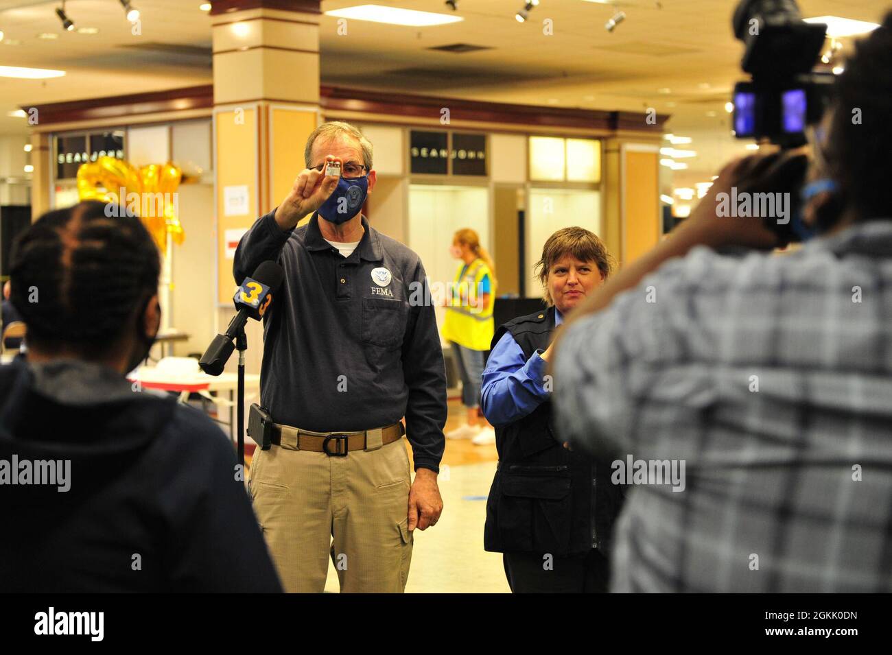 Tim Smith, directeur de site de l’Agence fédérale de gestion des urgences, tient des bouteilles de vaccins COVID-19 tout en s’adressant au personnel du canal 3 de la WTKR au Centre communautaire de vaccination géré par l’État et financé par le gouvernement fédéral de l’ancien Macy’s, au Military Circle Mall à Norfolk, en Virginie, le 10 mai 2021. Le Commandement du Nord des États-Unis, par l'intermédiaire de l'Armée du Nord des États-Unis, demeure déterminé à fournir un soutien continu et souple du ministère de la Défense à l'Agence fédérale de gestion des urgences dans le cadre de la réponse pangouvernementale à la COVID 19. Banque D'Images