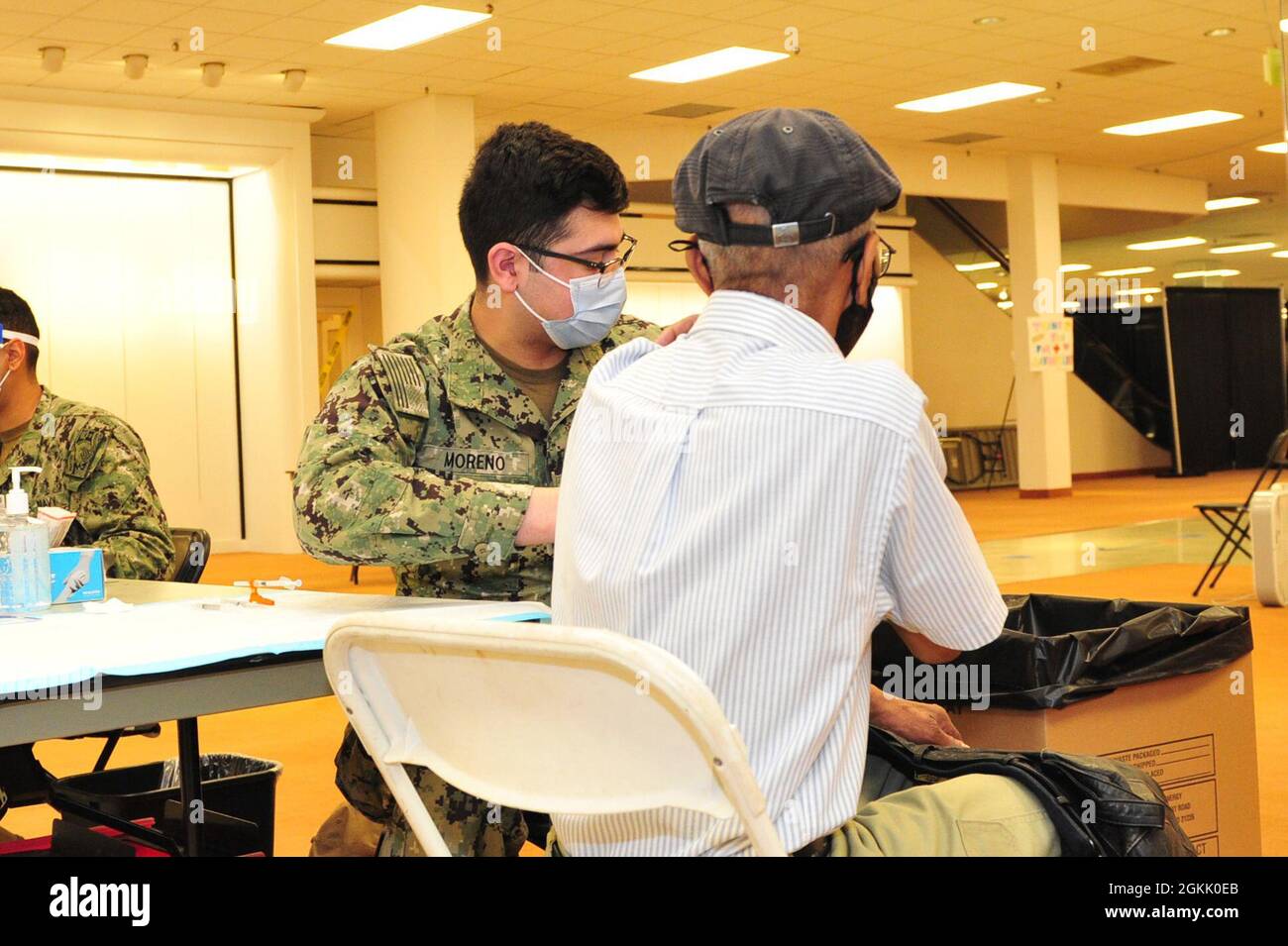 L'Hospitalman Sam Moreno de la Marine américaine administre un vaccin COVID-19 à un membre de la communauté à la vaccination communautaire gérée par l'État et appuyée par le gouvernement fédéral à l'ancienne Macy's au Military Circle Mall à Norfolk, en Virginie, le 10 mai 2021. Le Commandement du Nord des États-Unis, par l'intermédiaire de l'Armée du Nord des États-Unis, demeure déterminé à fournir un soutien continu et souple du ministère de la Défense à l'Agence fédérale de gestion des urgences dans le cadre de la réponse pangouvernementale à la COVID 19. Banque D'Images