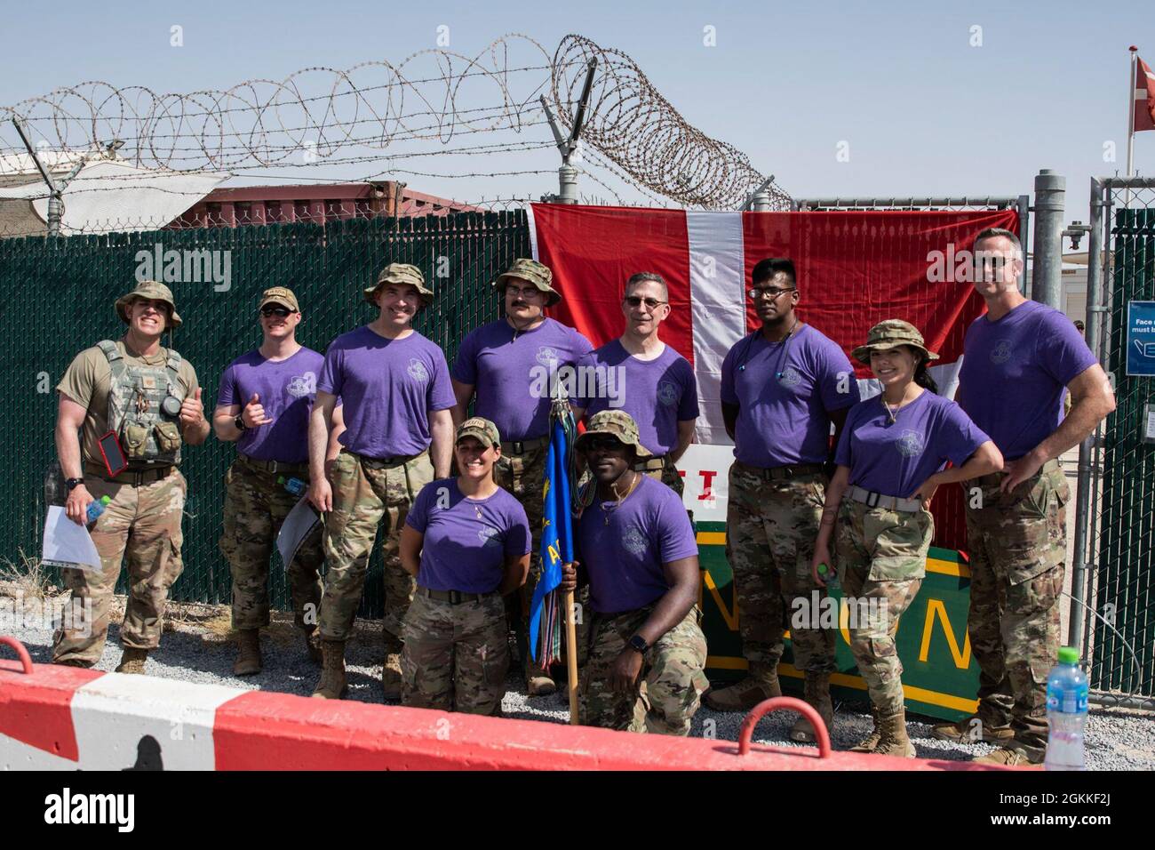 Les aviateurs affectés à la 386e Escadre expéditionnaire aérienne posent devant un drapeau danois après avoir terminé la Marche du contingent danois à la base aérienne Ali Al Salem, au Koweït, le 16 mai 2021. Les participants ont eu huit heures pour terminer la marche de 25 kilomètres de ruck tout en portant un poids total d'au moins 10 kilogrammes, environ 22 livres, pour être admissibles à la médaille de mars de DANCON. Banque D'Images