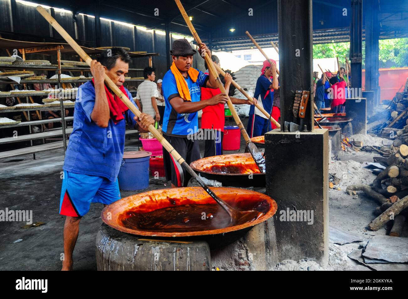 Les ouvriers de l'usine traditionnelle de gâteaux, à savoir les gâteaux Keranjang et Dodol, pétrissent la pâte qui est cuite sur un poêle à bois. Banque D'Images