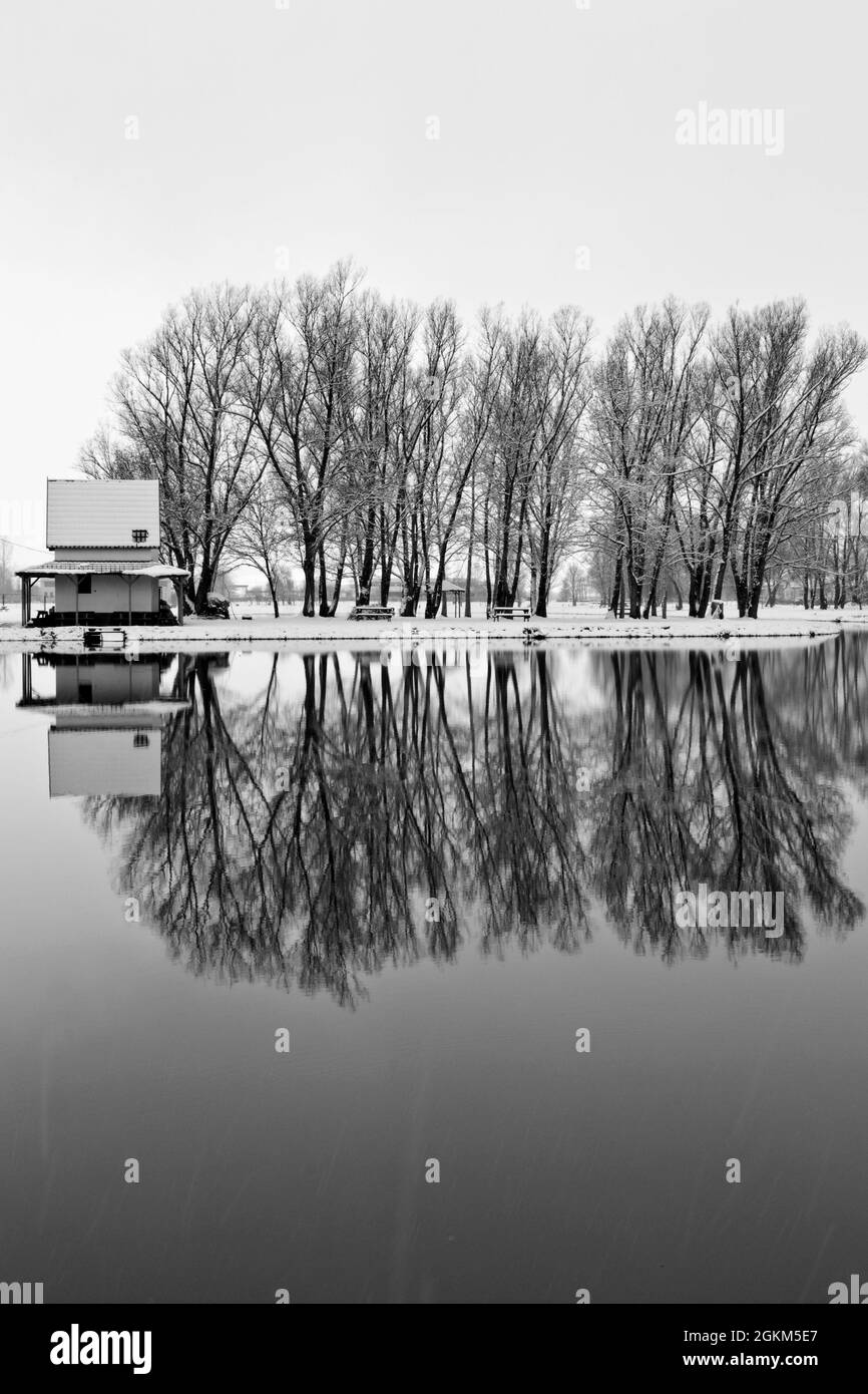 Petite maison de pêche sur le lac enneigé en hiver. Ózd, Hongrie. Banque D'Images