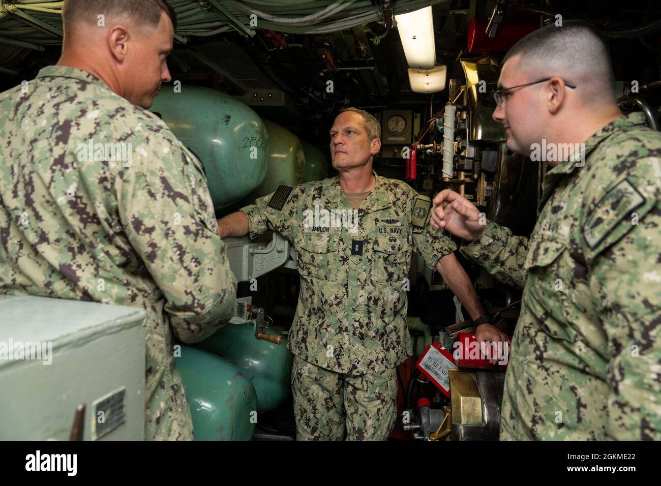 SANTA RITA, Guam (le 26 mai 2021) SMA arrière. Jeff Jablon (au centre), commandant de la Force sous-marine de la US Pacific Fleet, écoute le Mate de Torpedoman de 1re classe Brandon Morrow (à gauche) et le Mate de Torpedoman de 3e classe Sean Donnelly, tous deux affectés au sous-marin d'attaque rapide USS Key West (SSN 722) de Los Angeles, dans la salle torpille lors d'une visite du sous-marin. Jablon a visité Key West et d'autres unités de la base navale de Guam pour rencontrer des marins, discuter des opérations de l'unité avec la direction et évaluer les capacités de la zone de première main. Banque D'Images