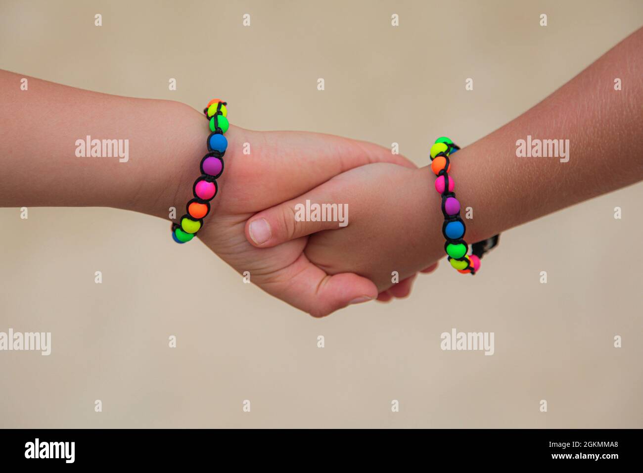 Les enfants tiennent les mains, bracelets colorés. Concept d'amitié. Banque D'Images