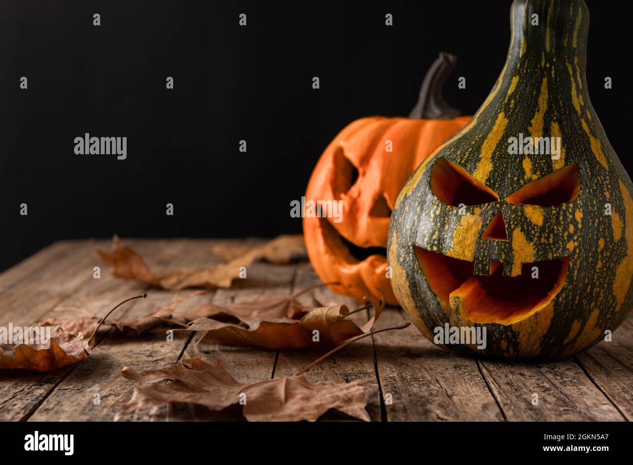 Citrouilles vertes d'Halloween sur table en bois et fond noir Banque D'Images