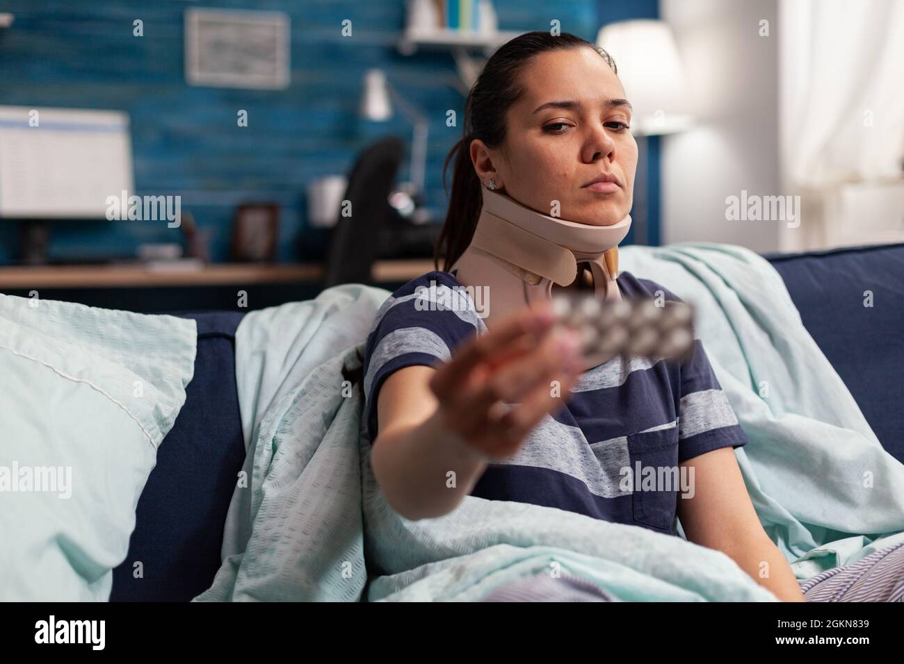 Femme atteinte de maladie et col de mousse cervicale sur le canapé prenant un traitement médical pour les douleurs au dos et au cou. Adulte caucasien présentant une contracture musculaire après une blessure physique dans un accident Banque D'Images