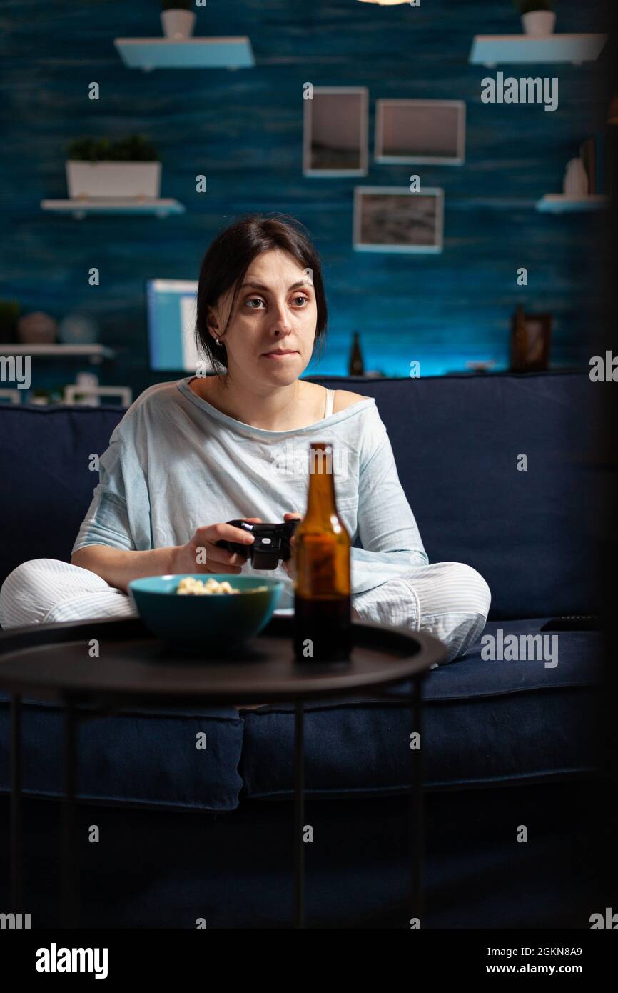 Colère déçue femme tenant le joystick de jeu jouant des jeux vidéo de football à la télévision perdant en ligne jeux vidéo concurrence. Personne expressive frustrée qui se délasser dans un pyjama relaxant tard dans la nuit Banque D'Images