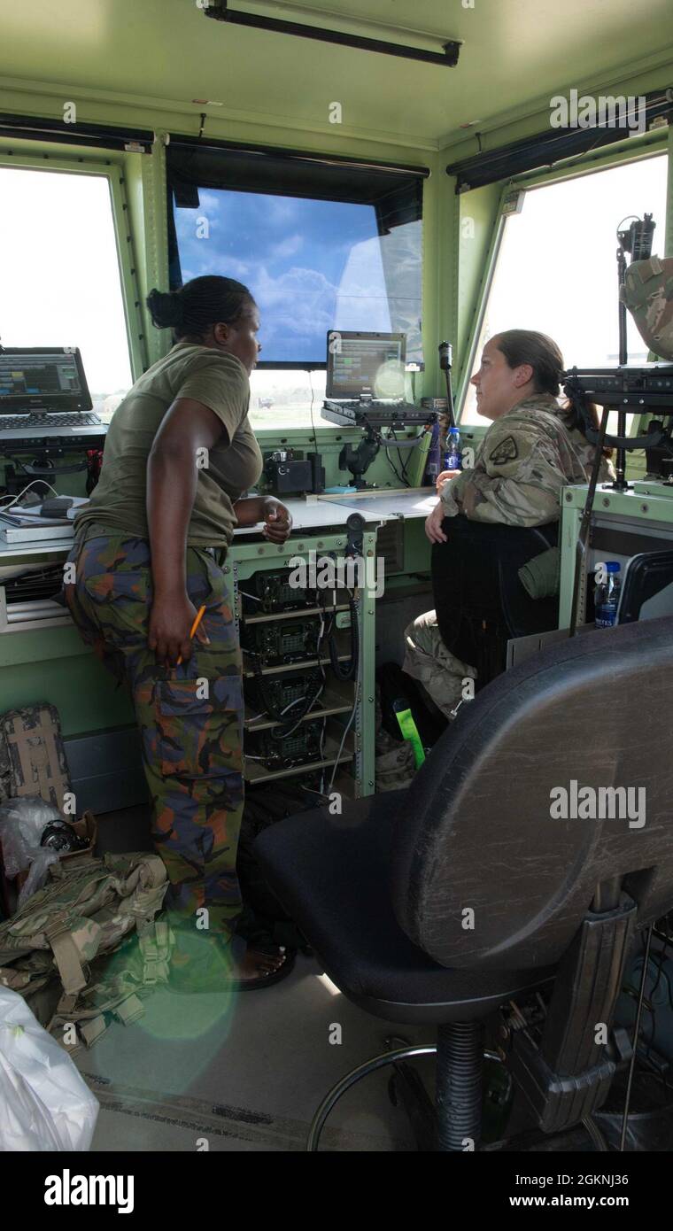 Contrôleur de la circulation aérienne de la marine kenyane, Priscilla, et Sgt de l'armée américaine. Elizabeth Adams, contrôleur de la circulation aérienne au sein du bataillon des opérations aéroportuaires (AOB) de 2-111, à l'appui de la Force opérationnelle interarmées combinée – Corne de l'Afrique (CJTF-HOA), discute de la préparation de l'aéronef kenyan à l'atterrissage à la piste d'atterrissage de Manda Bay, au Kenya, le 6 juin 2021. Les contrôleurs de la circulation aérienne (ATC) et la gestion des terrains d’aviation de l’AOB travaillent aux côtés des ATCS kenyanes pour établir les meilleures pratiques en matière de terrains d’aviation, ce qui donne aux soldats l’occasion d’établir des relations durables avec leurs homologues de la coalition. Banque D'Images