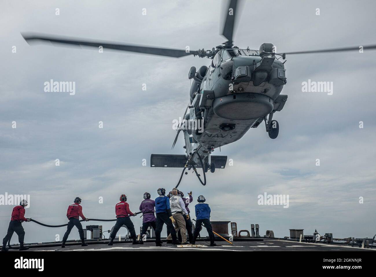 210607-N-XU073-1102 MER DE CHINE DU SUD (le 7 juin 2021) – des marins à bord du destroyer de missile guidé de classe Arleigh Burke USS Curtis Wilbur (DDG 54) ravitaillent un Hawk de mer MH-60R affecté à la frégate de classe Anzac de la Royal Australian Navy HMAS Ballarat (FFH 155) sur le pont de vol. Curtis Wilbur est affecté au commandant de la Force opérationnelle 71/Escadrier Squadron (DESRON) 15, la plus importante force de surface déployée à l’avant de la Marine et la plus importante force de surface de la 7e flotte américaine. Banque D'Images