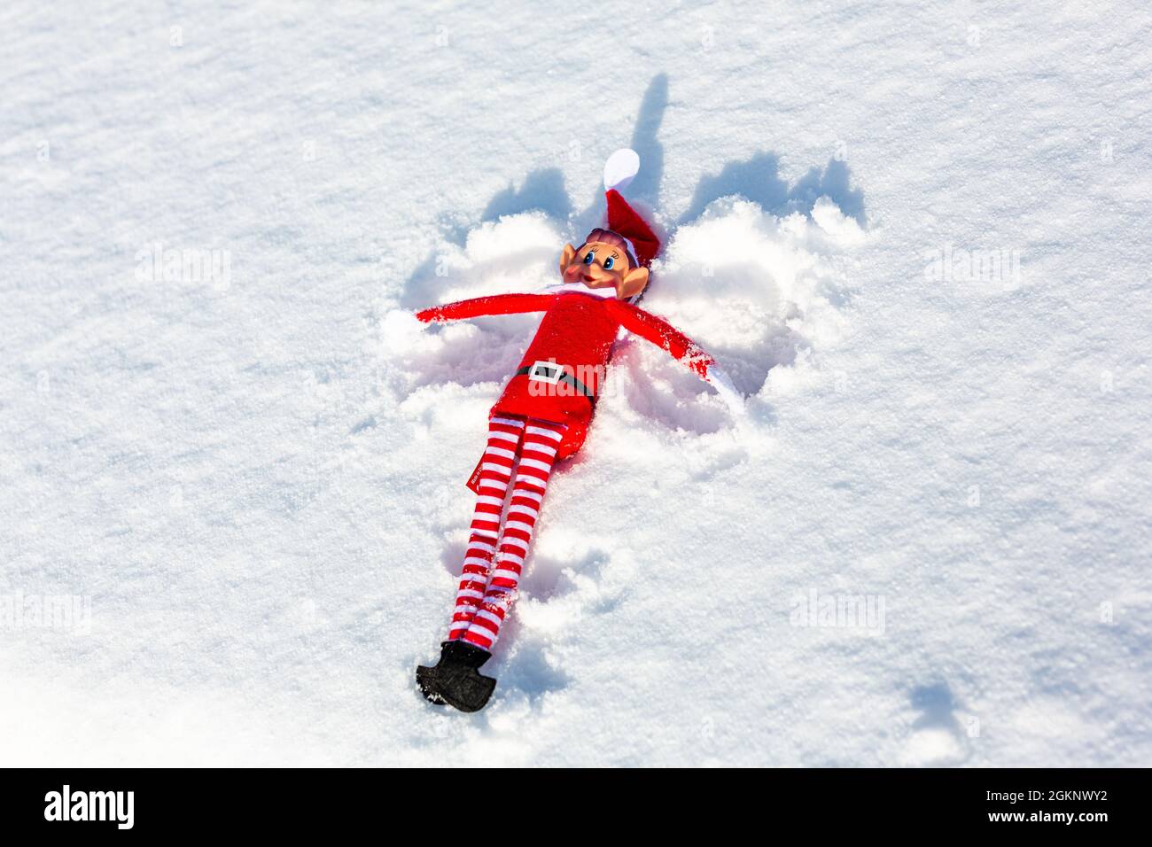 Un orf de Noël méchant qui fait des angles de neige dans la neige fraîche d'hiver. Elf sur l'étagère, naughty, noël, le concept d'elf espiègle Banque D'Images