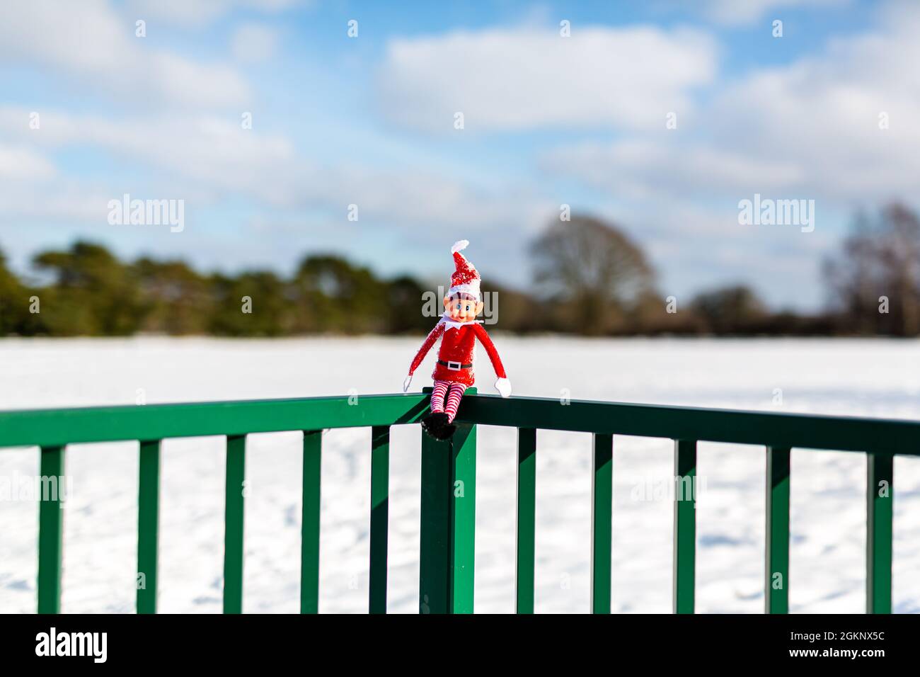Un lutin de Noël nain assis à l'extérieur dans le paysage d'hiver enneigé en profitant du soleil d'hiver. Elfe sur l'étagère, naughty, noël, espiègle Banque D'Images