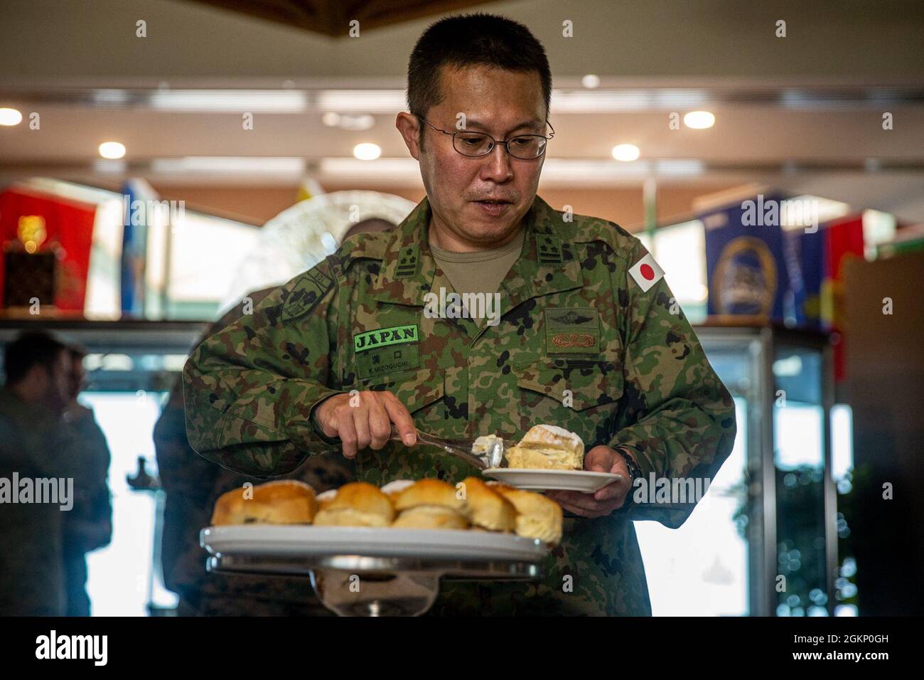 Kosyo Mizoguchi, commandant du 50e Régiment d'infanterie, prend une pâtisserie lors d'un thé du matin à Robertson Barracks, Darwin, territoire du Nord, Australie, le 9 juin, 2021. Des membres de la Force de défense australienne, de la Force de rotation marine - Darwin et du JGDSF ont assisté à l'événement pour se familiariser avec l'exercice trilatéral à venir, le sud de Jackaroo. Les liens de défense entre les États-Unis, leurs alliés et les pays partenaires sont essentiels à la sécurité et à la coopération régionales. Banque D'Images