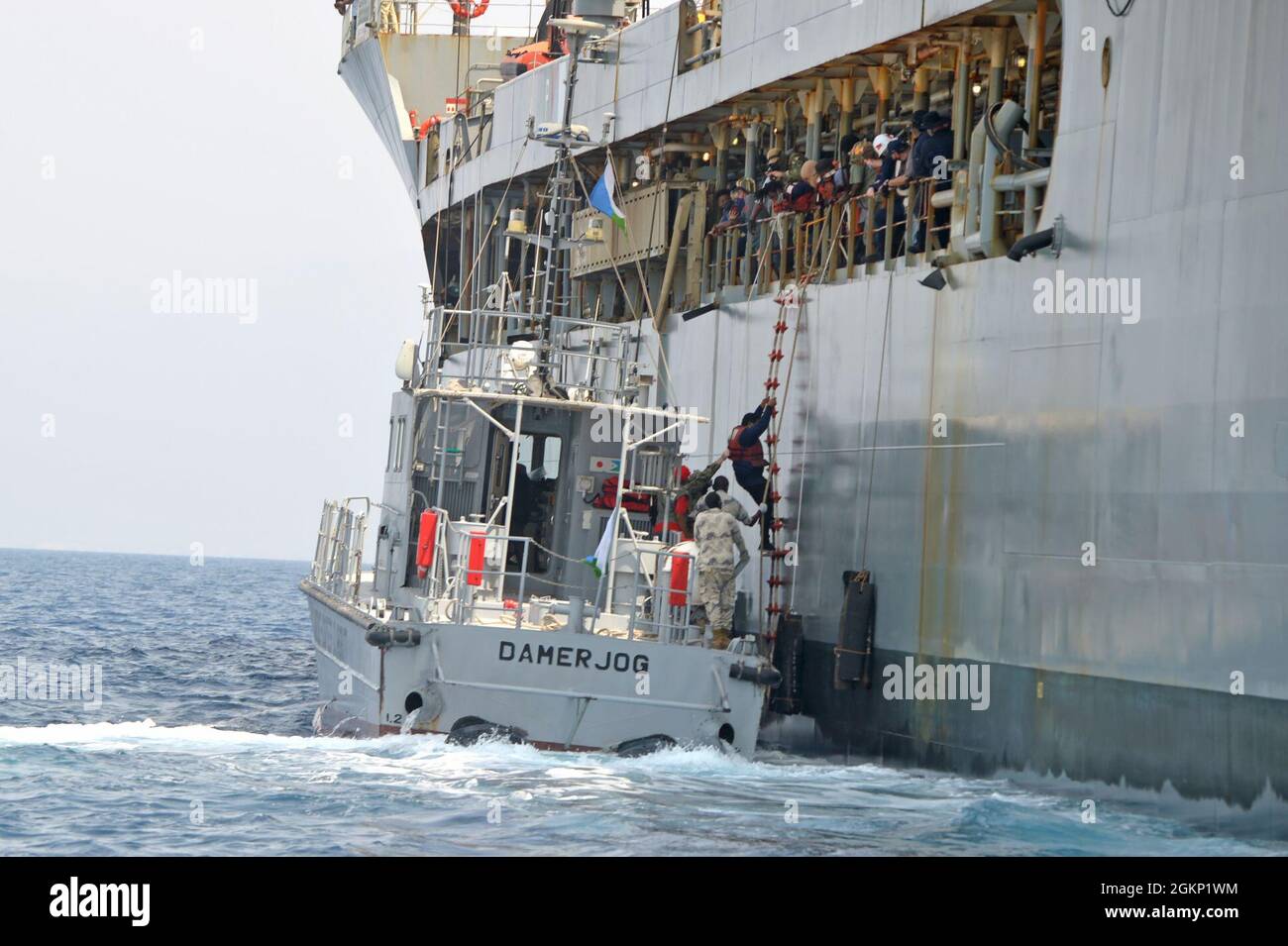 GOLFE DE TAJOURRA (10 juin 2021) 15 marins du navire submergé Falcon Line grimpent sur une échelle du Patuxent USNS au patrouilleur de la Garde côtière djiboutienne, DamerJog le 10 juin 2021. Patuxent opérait dans le golfe d'Aden le 9 juin, lorsque Falcon Line, un navire de fret général immatriculé au Gabon, s'enfonce. Patuxent est arrivé à temps pour secourir l'équipage. Jeudi, la Garde côtière djiboutienne a transféré l'équipage à la terre. Le Eleven (MSRON-11) de l'escadron de sécurité expéditionnaire maritime de la marine américaine, basé au Camp Lemonnier, a soutenu le transfert en assurant la sécurité autour de Patuxent et du Djibo Banque D'Images