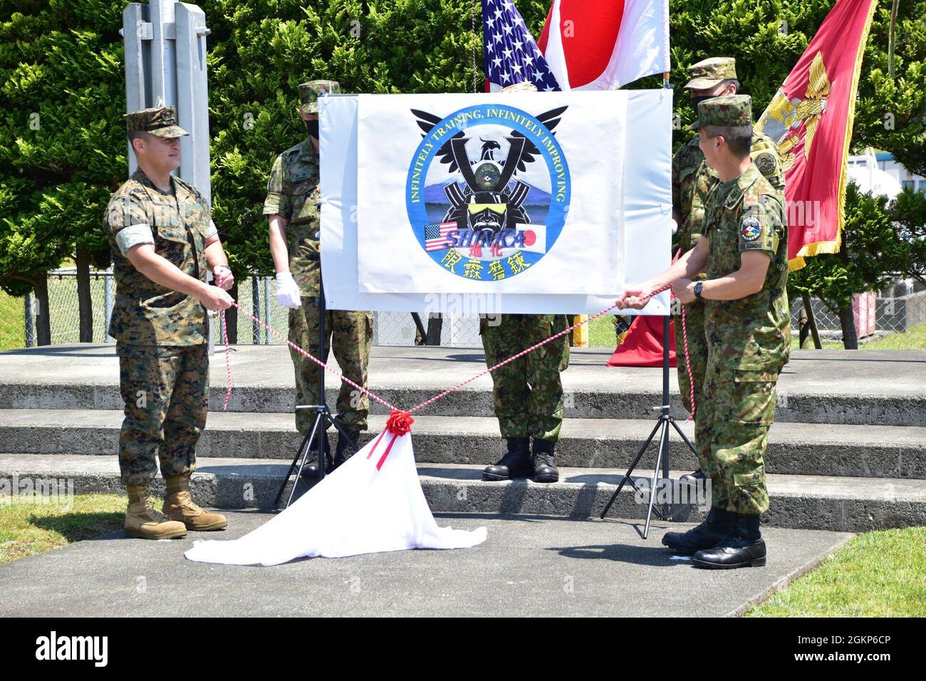 Le colonel Robert Bodisch du corps des Marines des États-Unis, commandant du camp Fuji du Centre d’entraînement des armes combinées, et le colonel Rikiya Kondo de la Force d’autodéfense au sol du Japon, commandant du centre d’entraînement du Fuji, dévoilent le logo de l’exercice Shinka lors de la cérémonie d’ouverture de l’exercice, au camp Fuji du CATC, au Japon, en juin 10. Shinka, qui signifie « évolution » en japonais, est conçu pour tester et développer les tactiques, les techniques, la technologie et les compétences qui assureront la capacité à aider à soutenir la défense du Japon. CATC Camp Fuji a aidé à faciliter l'exercice de force sur force dans le cadre de son engagement à fournir le cla mondial Banque D'Images