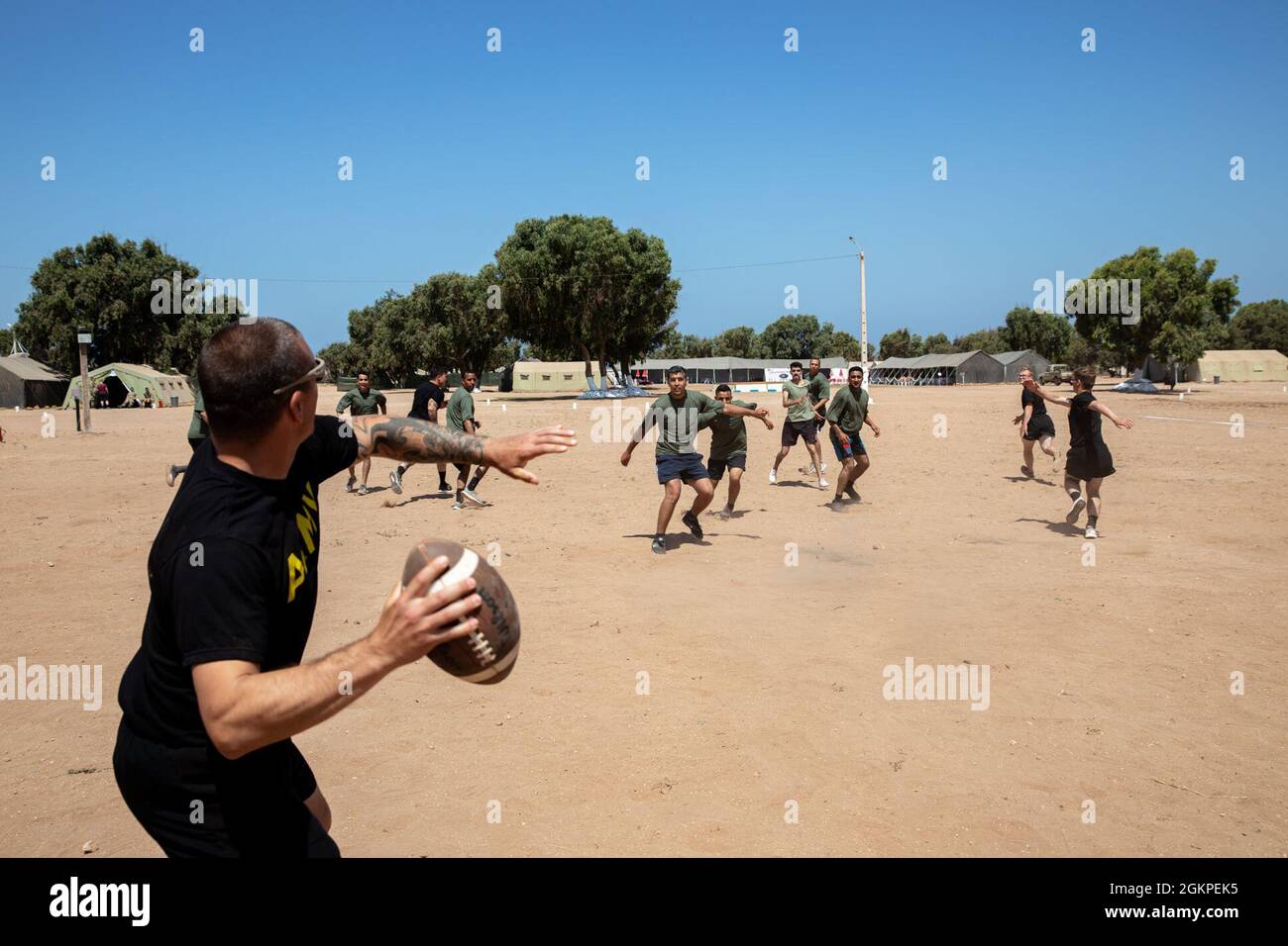 Les soldats américains affectés à la 551e compagnie de police militaire jouent au football américain avec les soldats marocains royaux, sous la direction de Marty Peters, un ancien arbitre professionnel de la Ligue nationale de football dans la zone d'entraînement de Tifnit, Maroc, le 13 juin 2021. African Lion 2021 est l'exercice annuel le plus important, conjoint et premier du Commandement de l'Afrique des États-Unis, organisé par le Maroc, la Tunisie et le Sénégal, le 7-18 juin. Plus de 7,000 participants de neuf pays et de l'OTAN s'entraînent ensemble en mettant l'accent sur l'amélioration de la préparation des forces américaines et des forces des pays partenaires. African Lion 21 est un exeur multidomaine, multicomposant et multinational Banque D'Images