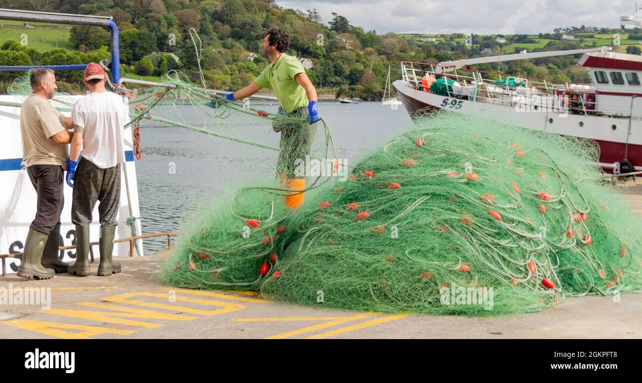 Pêcheur déchargeant des filets maillants monofilaments du chalutier. Banque D'Images