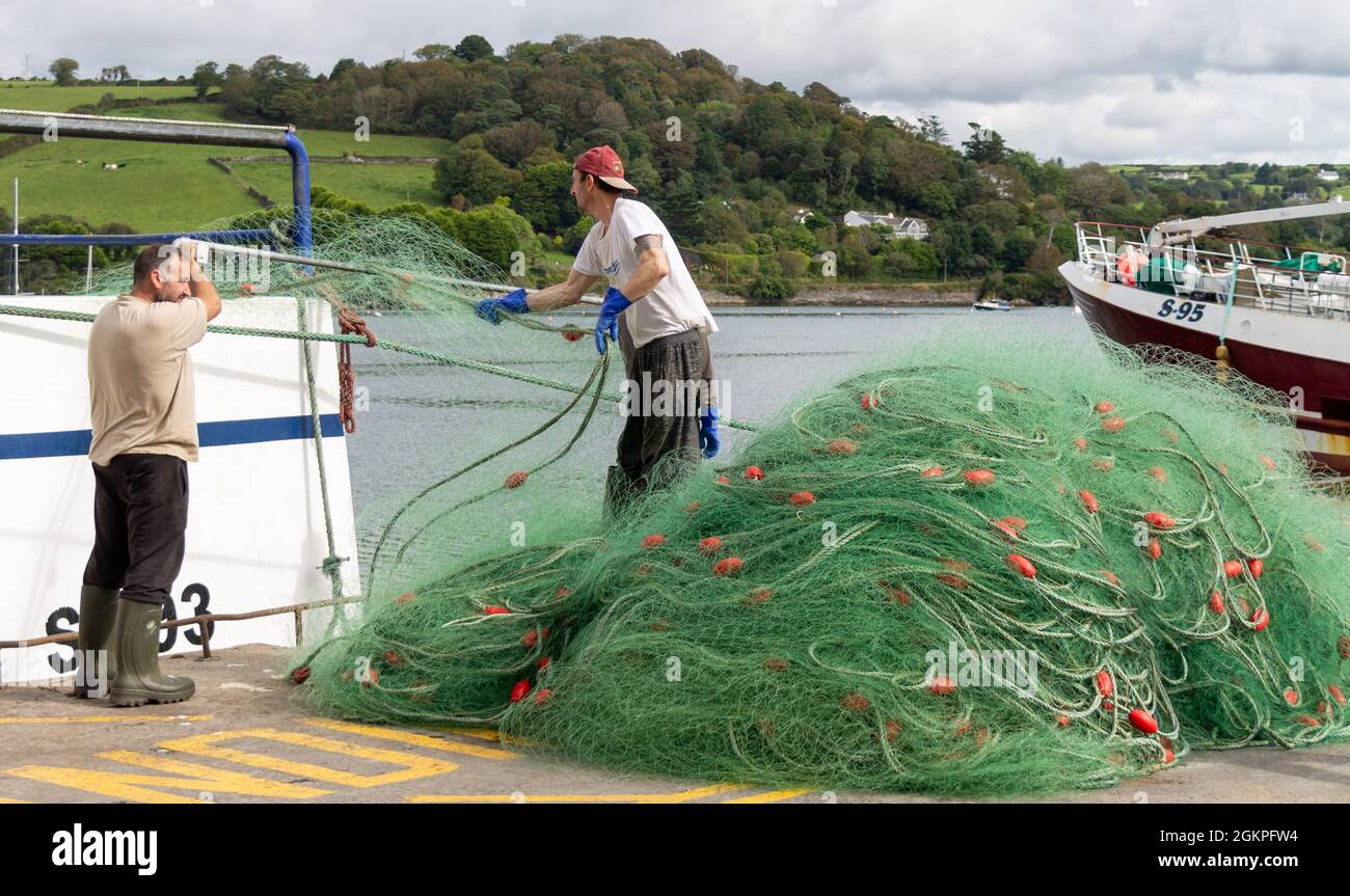 Pêcheur déchargeant des filets maillants monofilaments du chalutier. Banque D'Images