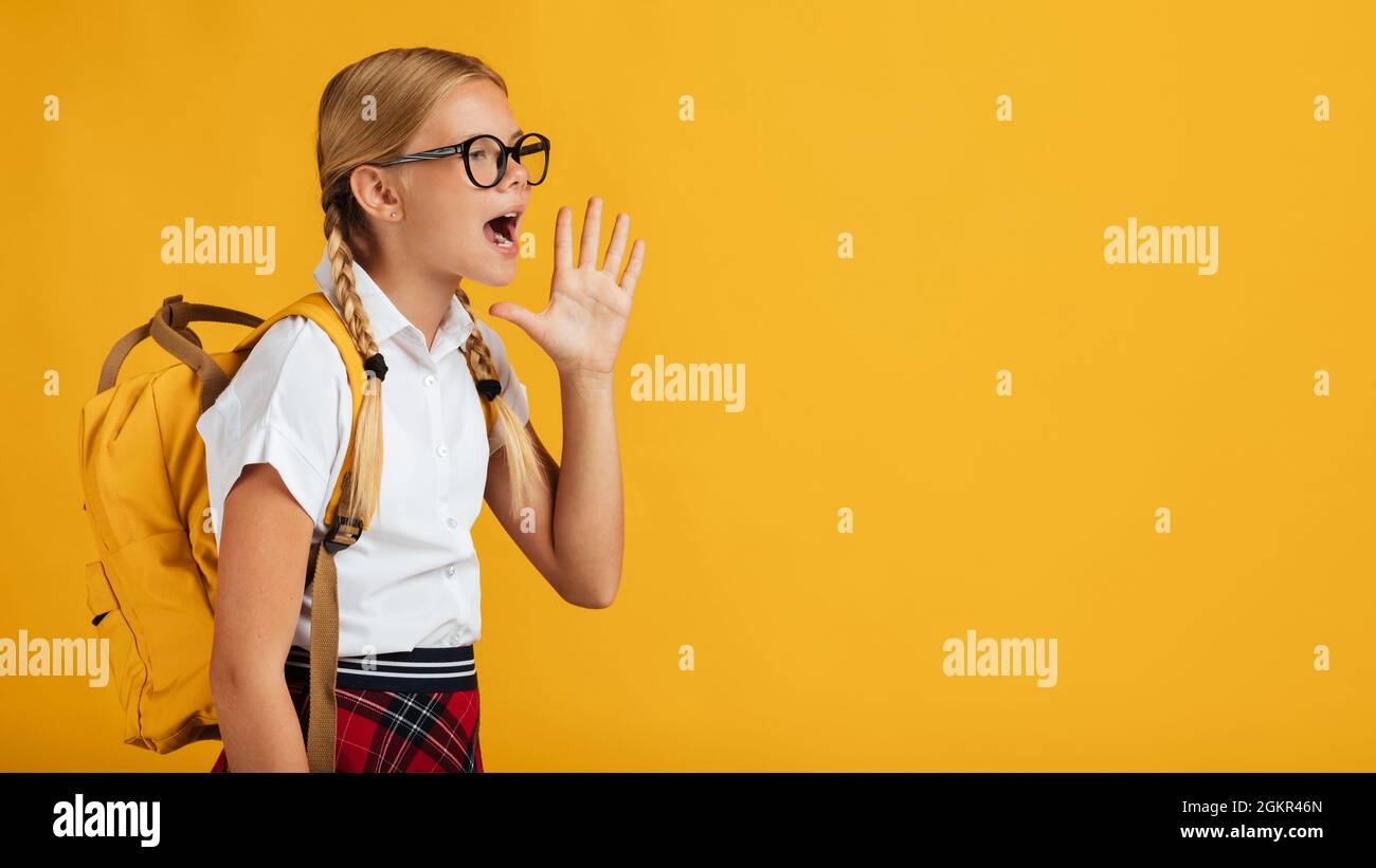 Adolescent blond drôle pupille avec des queues de porc, sac à dos en lunettes crits à l'espace libre Banque D'Images