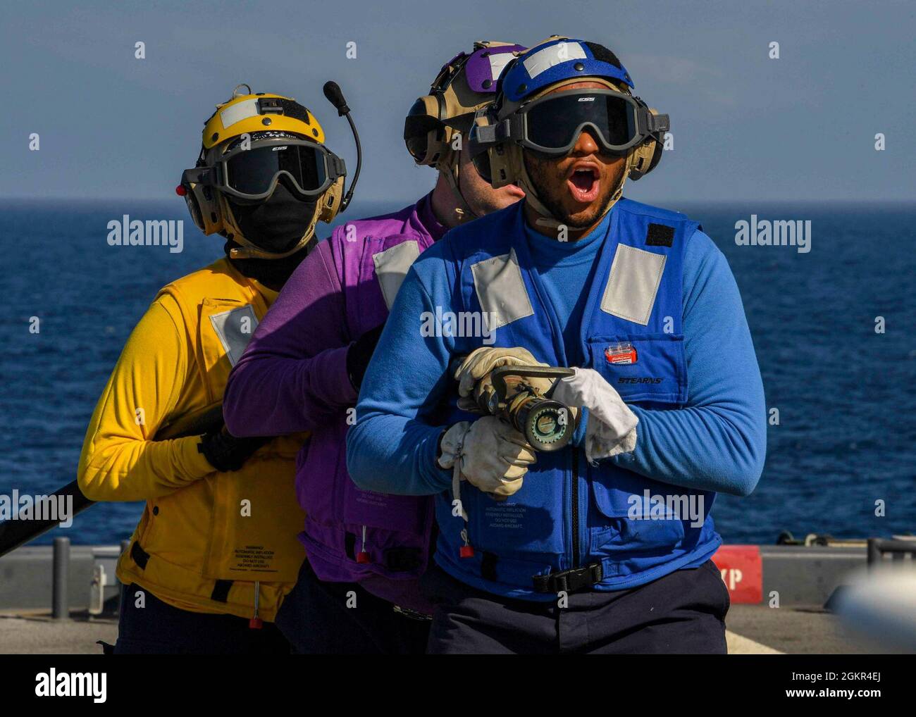 OCÉAN ATLANTIQUE (17 JUIN 2021) Airman Emery Mahamery, à droite, demande à son équipe de flexibles de se déplacer lors d'un accident et d'un exercice de récupération sur le pont de vol de la base maritime expéditionnaire USS Hershel « Woody » Williams (ESB 4) dans l'océan Atlantique, le 17 juin 2021. Hershel « Woody » Williams est en cours de déploiement prévu dans la zone d'opérations de la Sixième flotte américaine pour soutenir les intérêts nationaux et la sécurité des États-Unis en Europe et en Afrique. Banque D'Images