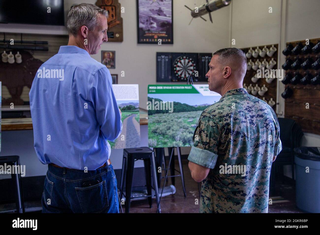 Tim Anderson, à droite, le commandant de la station aérienne du corps des Marines, Camp Pendleton, parle avec un représentant de Burns & McDonnell dans la salle Legacy sur la station aérienne du corps des Marines, Camp Pendleton, Californie, Au sujet des travaux que la station aérienne fait pour aider à restaurer l'habitat à Moosa Creek près de Bonsall, Californie, le 17 juin 2021. La station aérienne a acheté le site du ruisseau Moosa pour compenser l'habitat touché qui a perdu le défrichement des arbres à la fin de la piste 21. LE camp Pendleton des ACMS a établi un partenariat avec le U.S. Fish and Wildlife Service, des entreprises privées et divers organismes locaux et fédéraux Banque D'Images