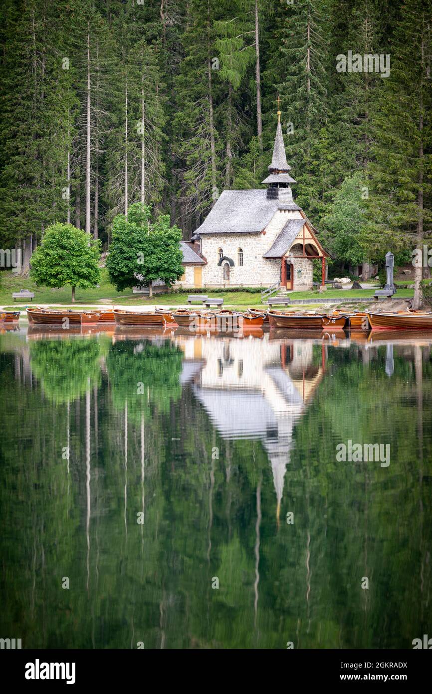 Forêt verte et chapelle parfaitement reflétée dans le lac Braies (Pragser Wildsee) en été, Dolomites, Tyrol du Sud, Italie, Europe Banque D'Images