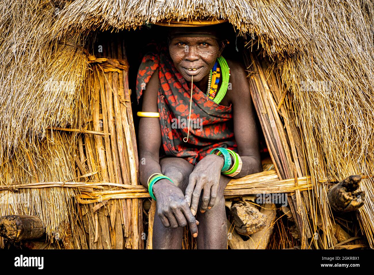 Cicatrice visage comme une marque de beauté sur la femme de la tribu Jiye assis dans sa hutte, État d'Equatoria de l'est, Soudan du Sud, Afrique Banque D'Images