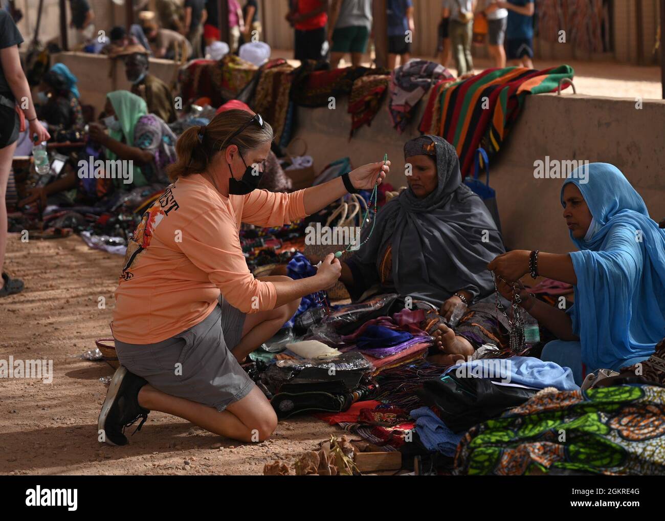 Un membre du service américain affecté à la base aérienne nigérienne 201 parcourt l’inventaire d’un vendeur au cours d’un bazar le 20 juin 2021 à la base aérienne 201, au Niger. Les membres de la base aérienne 201 ont injecté avec succès plus de 4.2 millions de francs CFA d'Afrique de l'Ouest, soit environ 14 mille dollars dans l'économie locale. Banque D'Images
