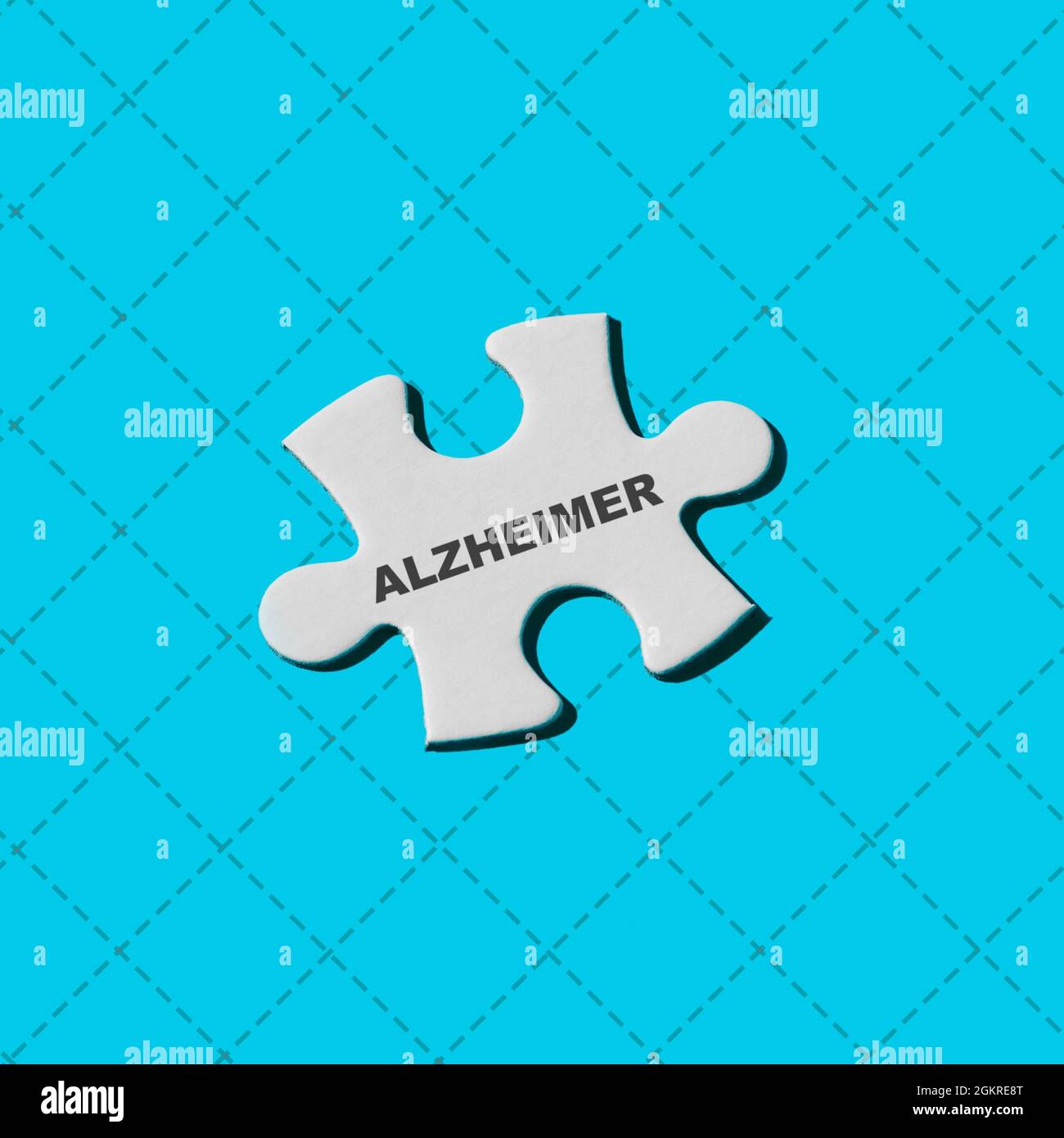 un puzzle blanc avec le mot alzheimer écrit dans lui sur un fond bleu Banque D'Images