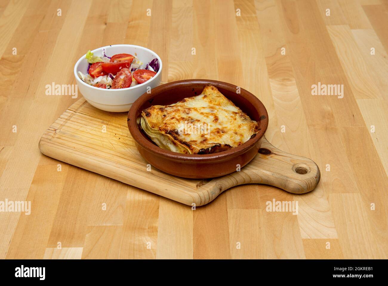 Grandes lasagnes au fromage avec des couches de pâtes, gratin de béchamel avec plus de fromage râpé et salade de tomates et de choux Banque D'Images