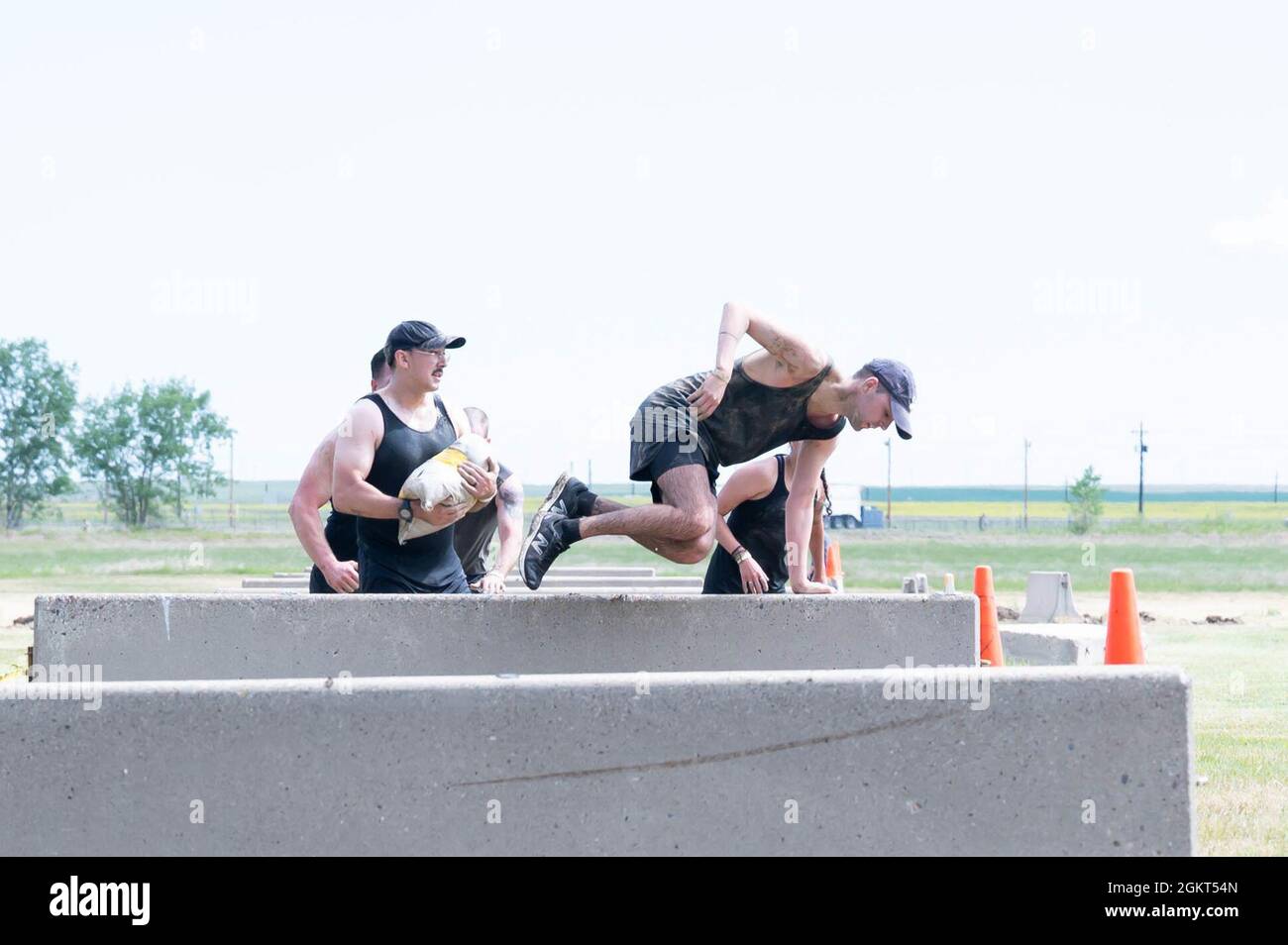 Les membres de la 341e Escadre des missiles grimpent sur des haies de béton lors de la course dégoûtante de Mudder le 25 juin 2021, à la base aérienne de Malmstrom, au mois de l'an. La course comprenait à la fois des compétitions d'équipe et des compétitions individuelles. Banque D'Images