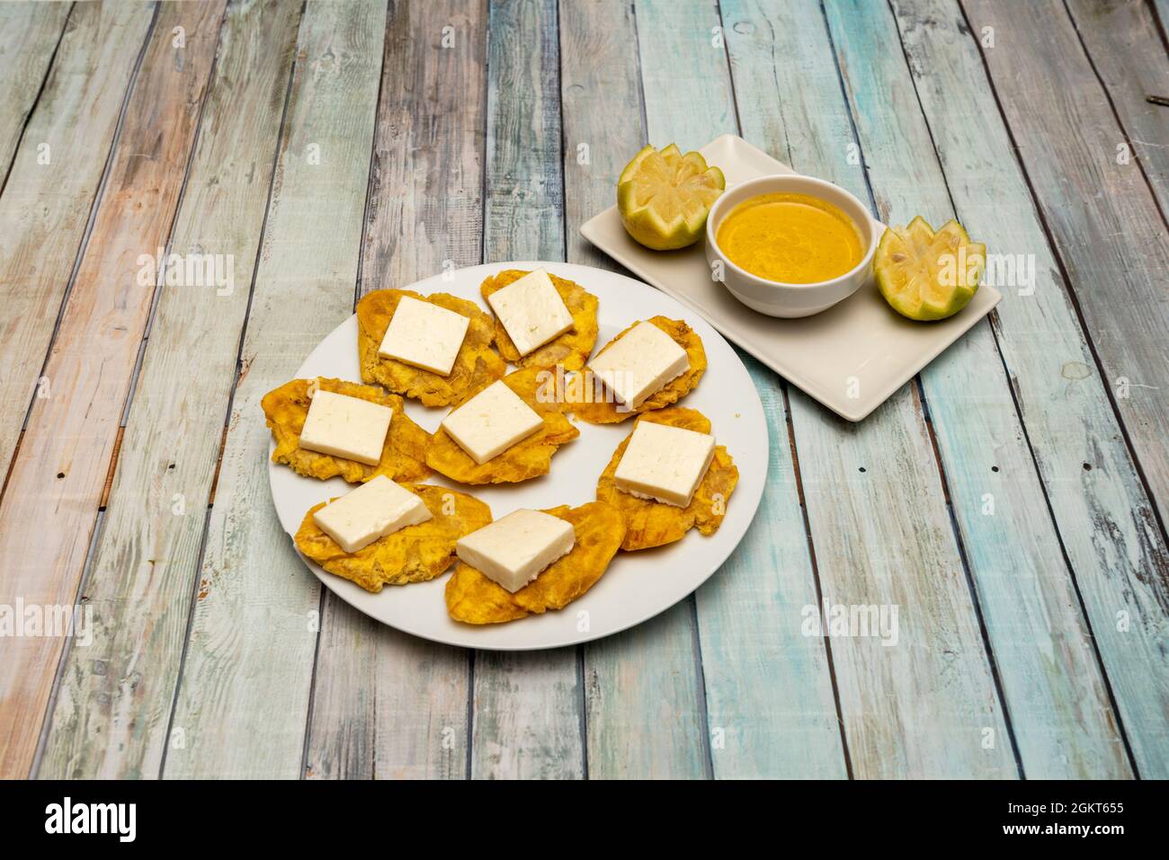 Assiette avec patacones plantain et fromage frais et sauce Chili pour trempette Banque D'Images