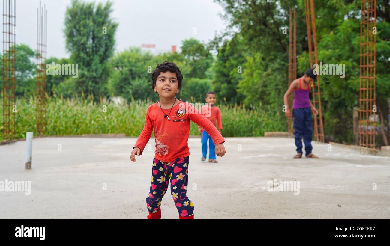 13 septembre 2021 Reengus, Rajasthan, Inde. Concentrez-vous sur la danse de la fille au sol et d'autres enfants qui dessinent sur le trottoir avec des craies. Vue avant. Enfants outd Banque D'Images