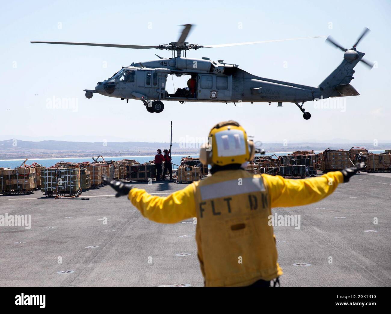 210701-N-GA608-1038 OCÉAN PACIFIQUE (le 1er juillet 2021) – le compagnon de bateau de la Marine américaine Airman Paul Esteba, à droite, dirige un buse de mer MH-60S, affecté à l’Escadron de combat de la mer (HSC) 23, tandis que l’officier d’aviation Airman Jeremiah Tracy, à gauche, Et l'Ordnanceman de l'aviation de 3e classe, Aundrey Chandler, attache des cargaisons lors d'un déchargement de munitions à bord du navire d'assaut amphibie USS Makin Island (LHD 8). L'île Makin mène des opérations de routine dans la zone d'exploitation de la 3e flotte des États-Unis. Banque D'Images