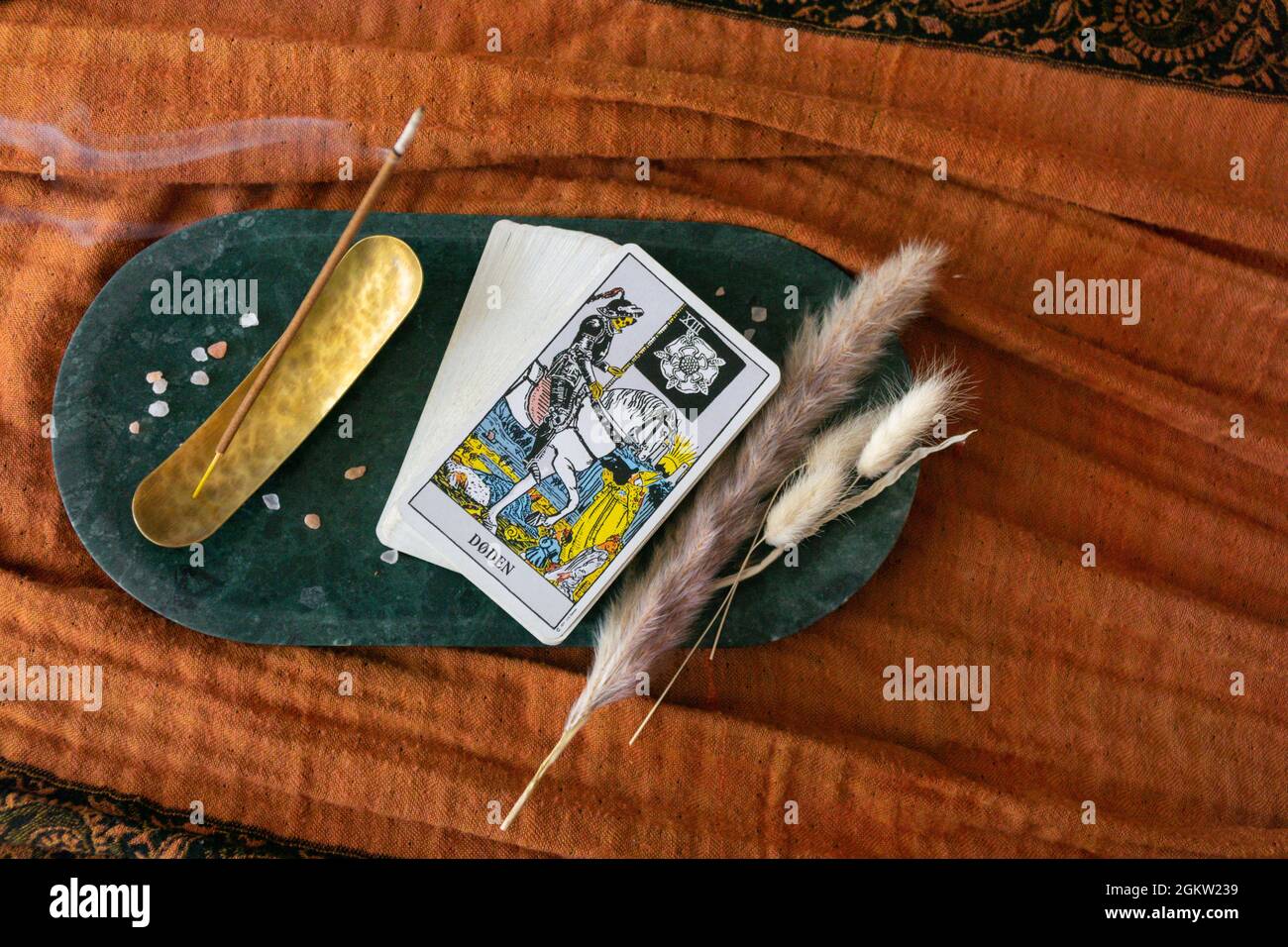 un panier de tarot lisant où la mort de carte est montré écrit en norvégien. encens, plaque de pierre et fond orange Banque D'Images