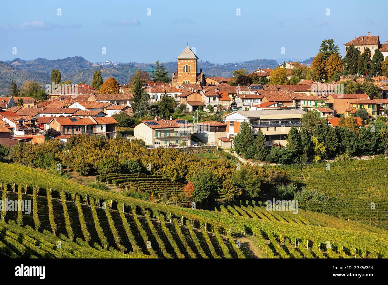 Vue sur les vignobles d'automne sur la colline et petite ville en arrière-plan dans le Piémont, dans le nord de l'Italie. Banque D'Images