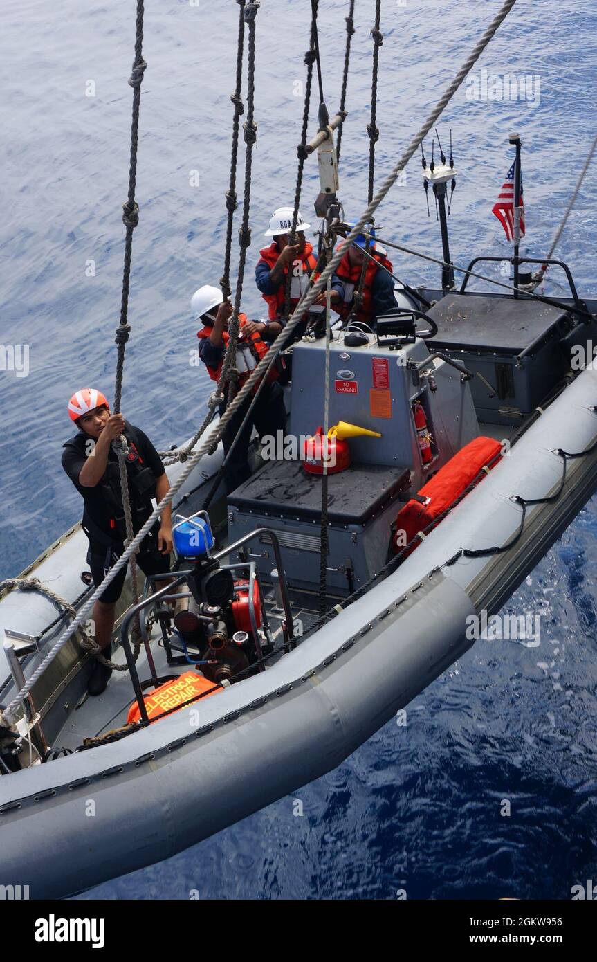 210707-N-CF707-1001 OCÉAN PACIFIQUE (le 7 juillet 2021) des marins affectés au croiseur de classe Ticonderoga USS Lake Champlain (CG 57) abaissent un bateau gonflable à coque rigide (RHIB) pour le rétablissement, le 7 juillet 2021. Le lac Champlain mène actuellement des opérations de routine dans la zone d'exploitation de la 3e flotte des États-Unis. Banque D'Images