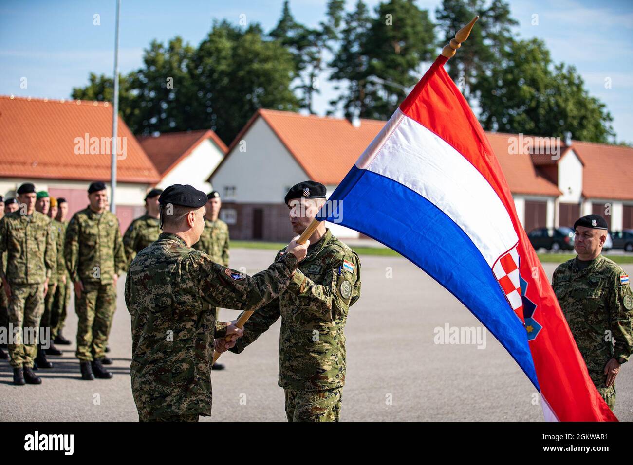 De gauche à droite, le Maj. Ivo Koscevic, commandant de la batterie du volcan, remet le drapeau de Croatie au capitaine de l'armée croate Dario Biljeskovic, commandant de la batterie de tempête, lors d'une cérémonie de transfert d'autorité à la zone d'entraînement de Bemowo Piskie, en Pologne, le 9 juillet 2021. Volcano Battery a mis fin à la septième rotation du contingent croate au groupement tactique Pologne. Banque D'Images