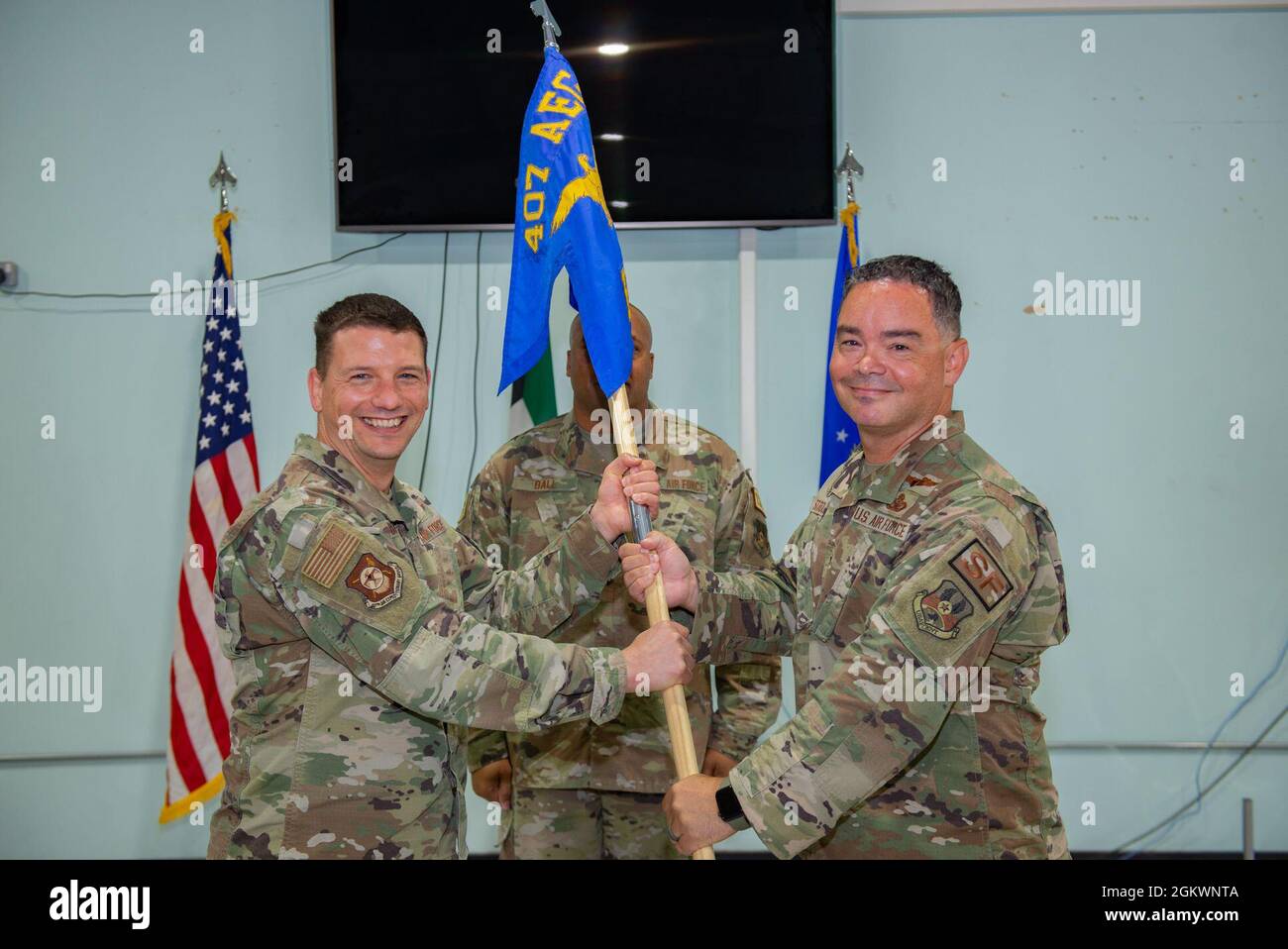 Le lieutenant-colonel Shawn Stroup de la Force aérienne des États-Unis (à droite), commandant entrant du 407e Escadron de la sécurité expéditionnaire, accepte le guide du colonel de la Force aérienne des États-Unis Jason Barnes, commandant (à gauche) du 407e Groupe expéditionnaire de la Force aérienne, lors d'une cérémonie d'accession au commandement à la base aérienne Ahmad Al Jaber, au Koweït, le 12 juillet, 2021. Une cérémonie de prise de commandement utilise un guide pour symboliser le transfert des responsabilités au nouveau commandant. Banque D'Images