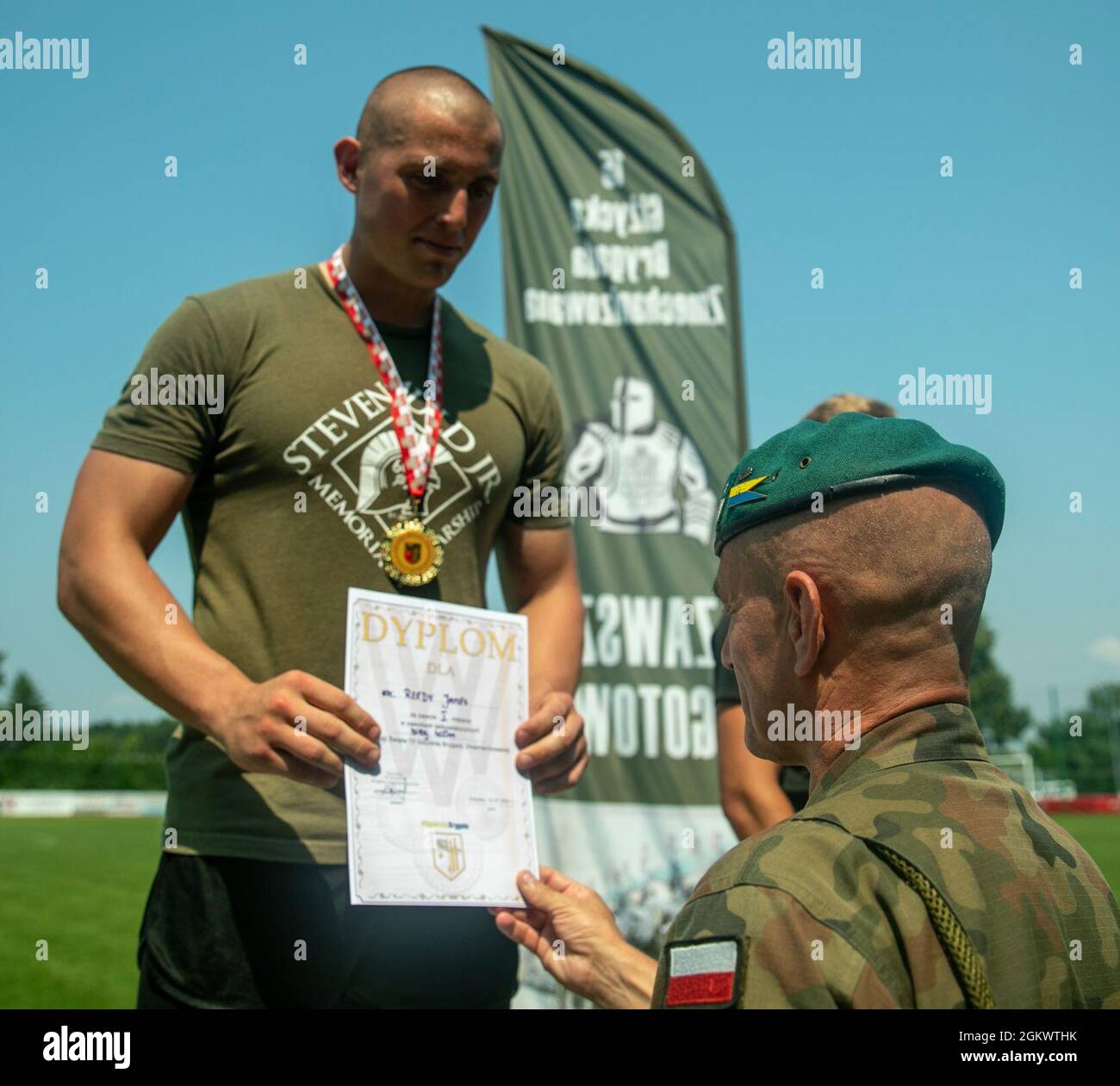 Forces terrestres polonaises, 15e Commandant de brigade mécanisé, Brig. Le général Bogdan Rycerski, remet à la CPS le prix de la première place de la course de 400 mètres. James Reedy au Stadion Miejski MOSIR à Giżycko, Pologne le 13 juillet 2021. Le groupe de combat Pologne comptait 40 concurrents représentant l'armée des États-Unis, l'armée britannique et les forces terrestres roumaines pour participer à l'épreuve sur piste et sur le terrain, qui comprenait des courses de 100 mètres, 400 mètres, 800 mètres et 4 X 400 mètres ainsi que des compétitions de lancer de javelot, de tir et de saut long. L'événement inaugral multinational de piste et de terrain a eu lieu pour célébrer la 15e Brigade mécanisée des Forces terrestres polonaises Banque D'Images