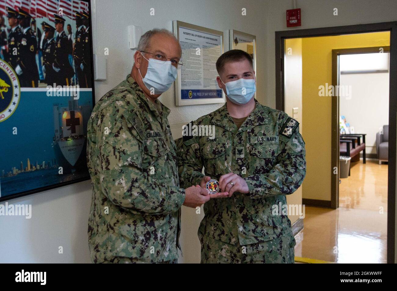 210713-N-AU520-1040 SAN DIEGO (13 juillet 2021) ADM. Arrière Bruce Gillingham, chirurgien général de la Marine et chef du Bureau de médecine et de chirurgie (BUMED), remet une pièce à l’Hôpital Corpsman de 3e classe Benjamin Shaw, responsable du centre de triage de la clinique de la Division de sensibilisation opérationnelle en santé mentale (CODO) à bord de la base navale de San Diego (NBSD) au cours d’une tournée le 13 juillet. Gillingham a visité le NMRTC de San Diego pour rencontrer des marins et du personnel, et a visité une clinique de santé mentale, un laboratoire dentaire avancé et USNS Mercy. La mission du NMRTC de San Diego est de préparer les membres du service à se déployer à l’appui des opérations Banque D'Images