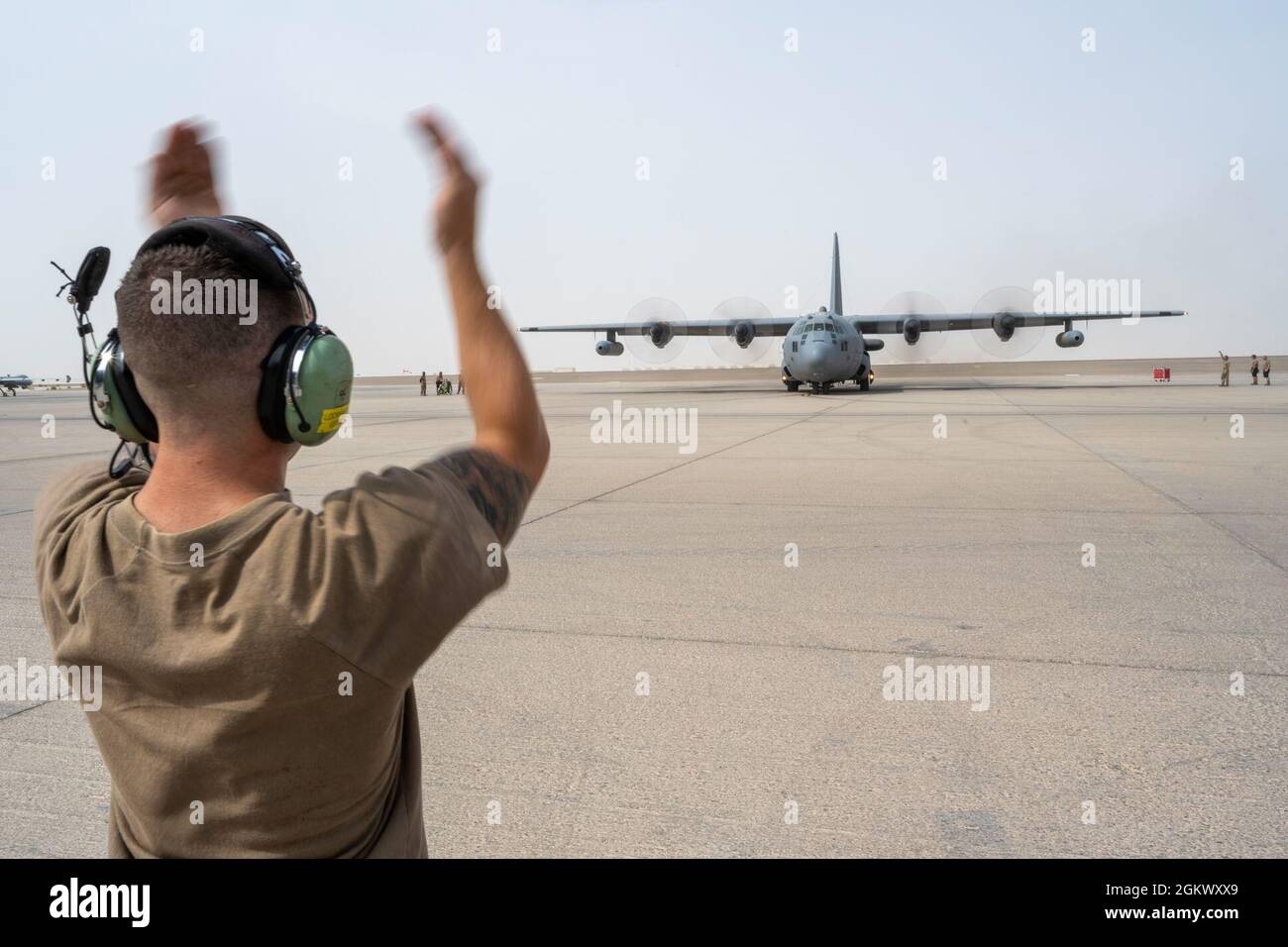 U.S. Air Force Airman 1re classe Austin Lockhart, 380e chef d'équipage du Escadron de maintenance d'aéronefs expéditionnaires, salue un avion Compass Call EC-130H alors qu'il se prépare à prendre son envol à l'appui d'un important exercice d'emploi de la force à la base aérienne Al Dhafra, aux Émirats arabes Unis, le 13 juillet 2021. Les exercices LFE offrent à l'ADAB et à d'autres forces du CENTCOM et de la coalition une occasion unique de s'entraîner avec des partenaires internationaux à des tactiques avancées avec un large éventail de missions. Banque D'Images