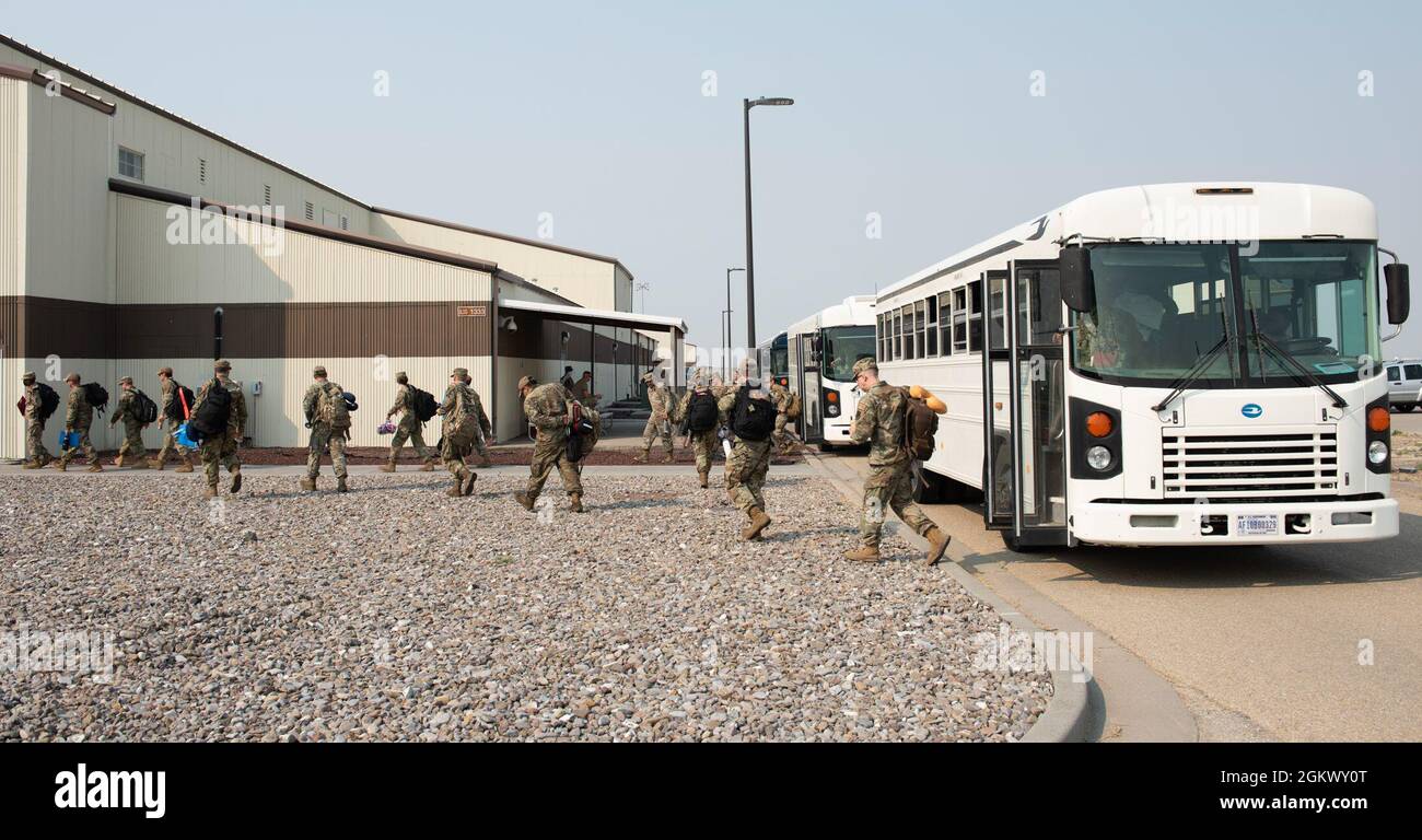 Les aviateurs de la US Air Force de plusieurs escadrons quittent l'autobus et entrent dans le bâtiment Chemical Gear, le 13 juillet 2021, à la base aérienne de Mountain Home, Idaho. Au sein du bâtiment des engins chimiques se trouve l'équipe de déploiement du personnel, c'est là que les aviateurs vont quand ils sont sur le point de se déployer. Banque D'Images