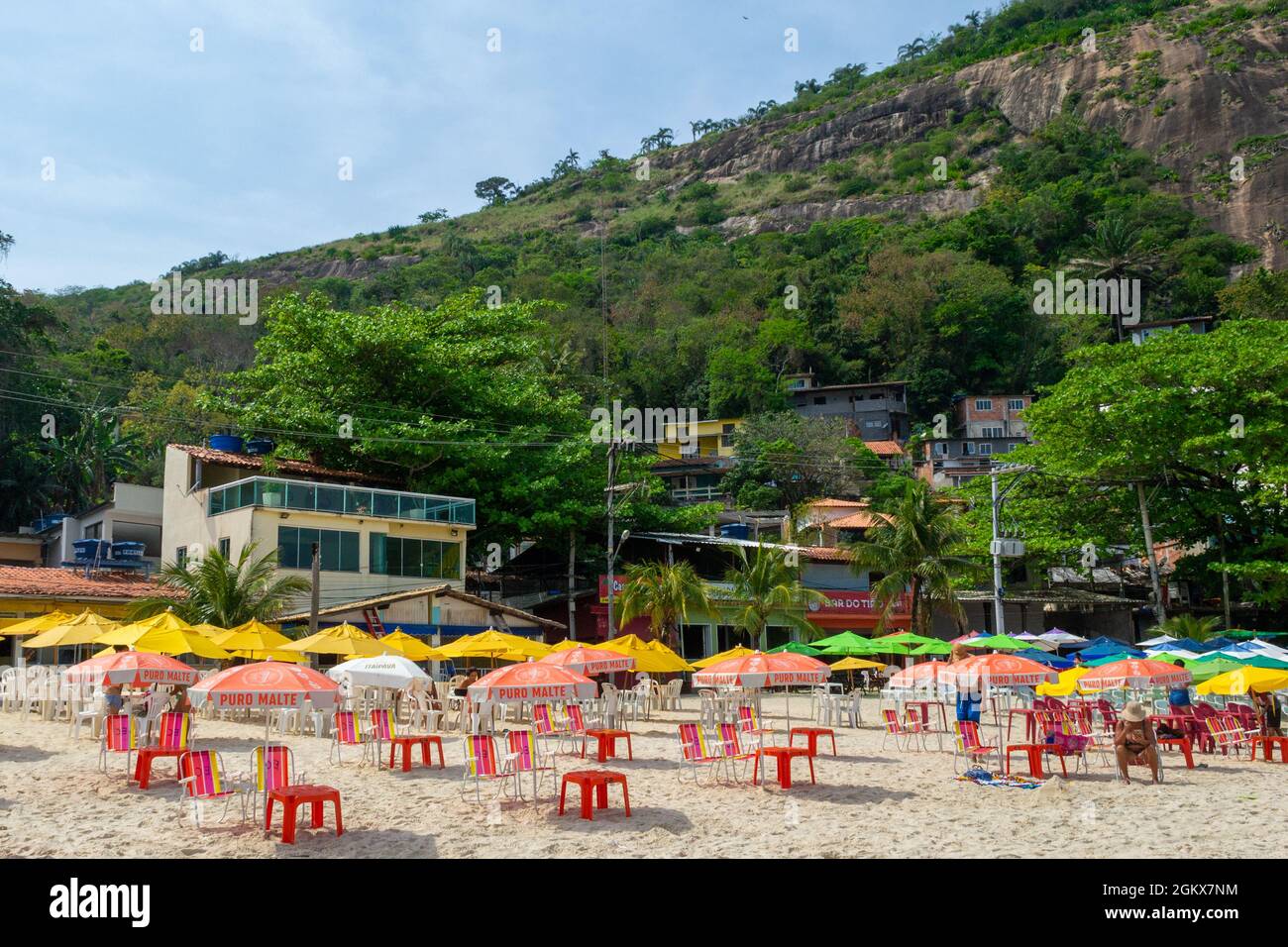 Plan de tables et parasols près d'une montagne à la plage d'Itaipu, Rio de Janeiro, Brésil. Le célèbre endroit est une attraction touristique majeure. Banque D'Images