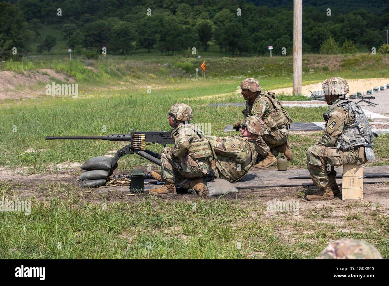 SPC. Nolan Mumford, spécialiste du fret du 650e Groupe de soutien régional, 79e Commandement du soutien du théâtre, tire un fusil machine Browning M2 .50 Caliber pendant les qualifications d'armes, le 16 juillet 2021, pendant la grève de Pershing 21 à fort McCoy, Wisconsin, tandis que l'assistant tireur SPC. Ian McEvers, également un spécialiste du fret avec le 645e CITC, regarde pour vérifier les hits. Le 645e CITC se prépare à un prochain déploiement au CENTCOM. Banque D'Images