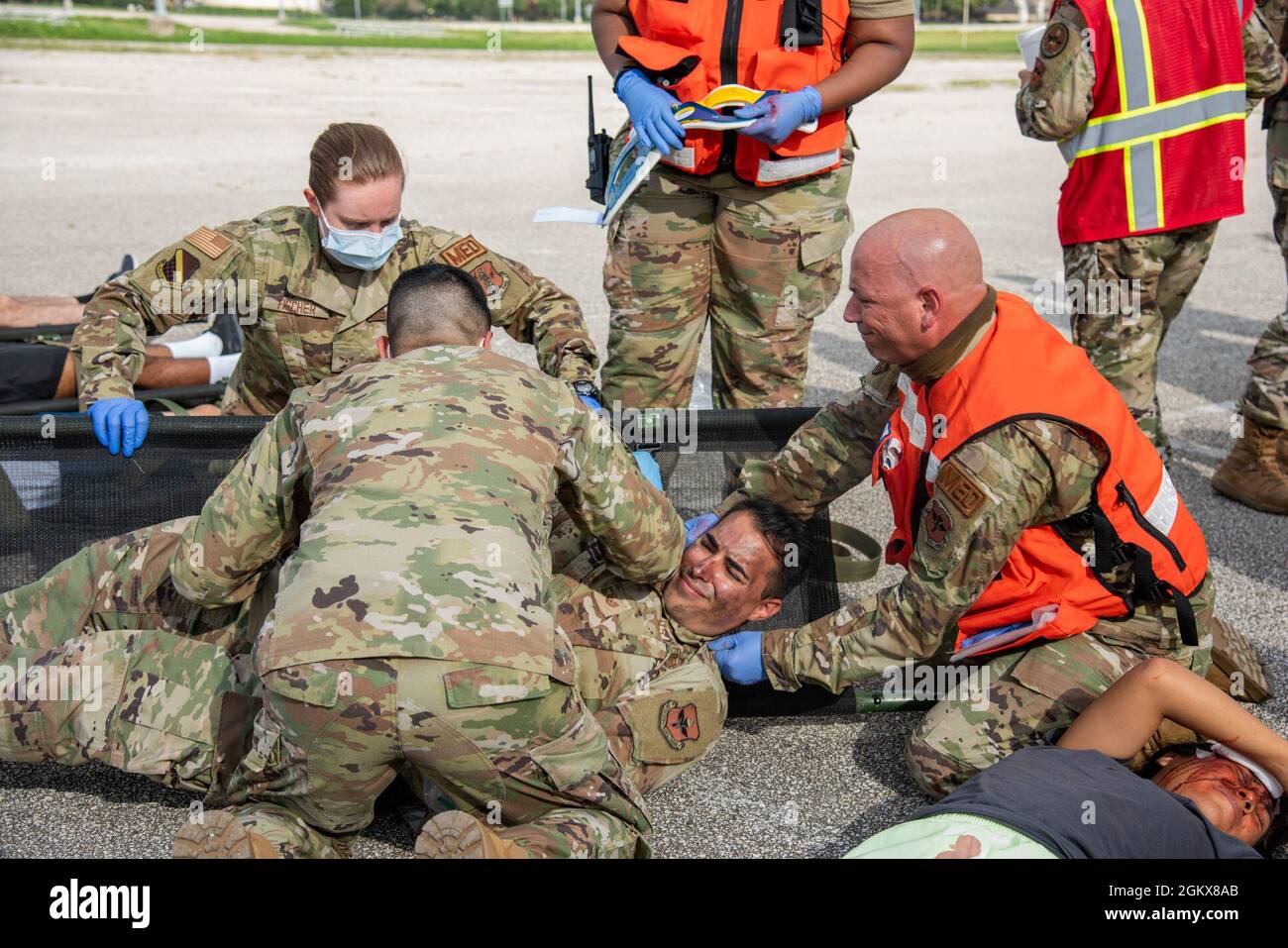 Un groupe d'aviateurs positionnent un patient simulé sur un litre pendant l'exercice d'EAGLE Ready Capstone à la joint base San Antonio-Lackland, Texas, le 16 juillet 2021. Les médecins traitent les patients simulés comme lors d'un incident de masse réel afin d'affiner leurs compétences en matière d'intervention d'urgence. Banque D'Images